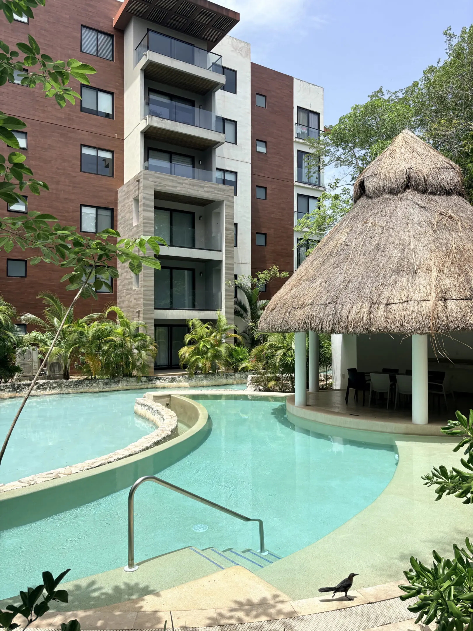 Apartment pool with thatched-roof palapa