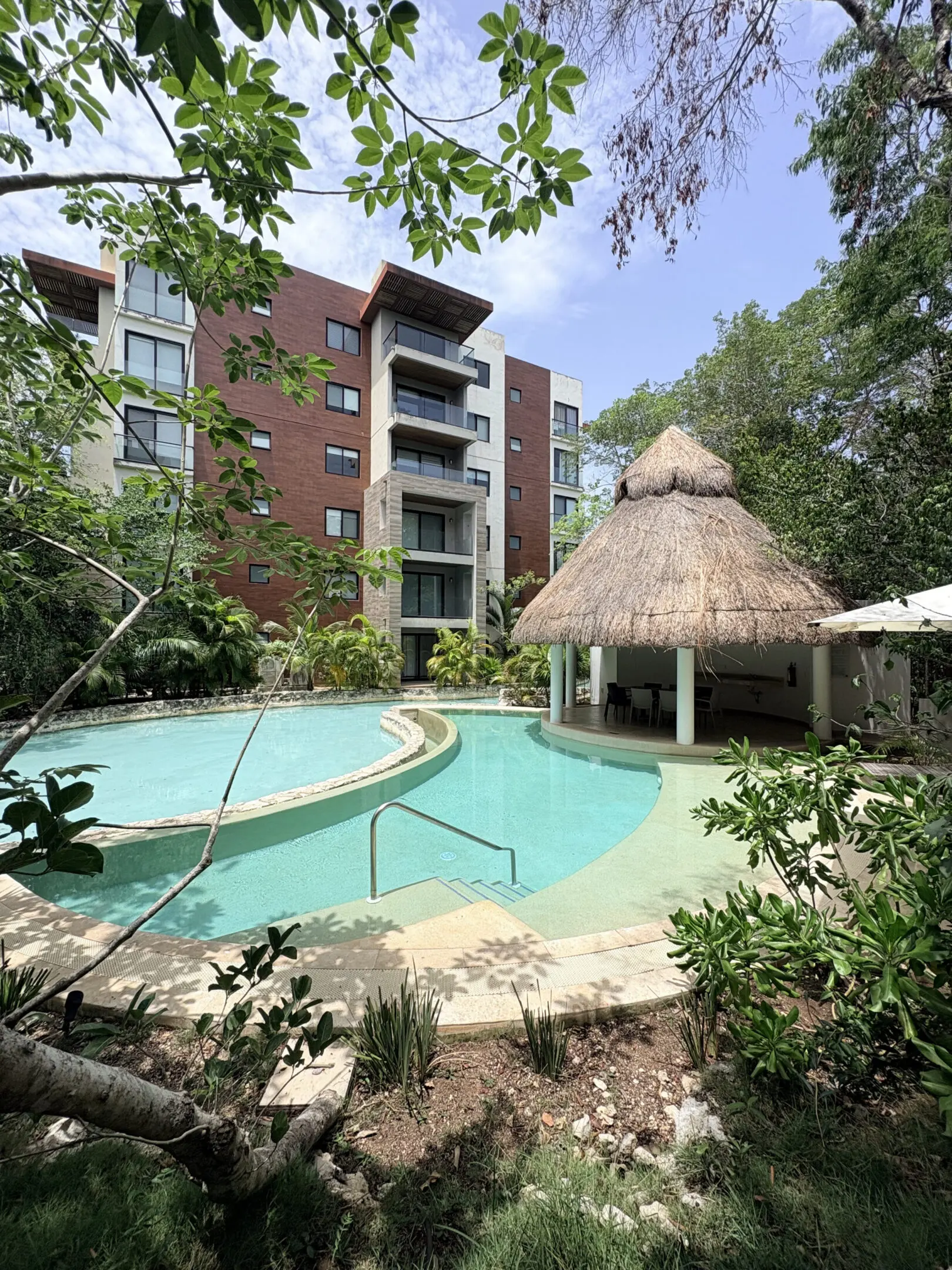 Tropical apartment pool with thatched palapa