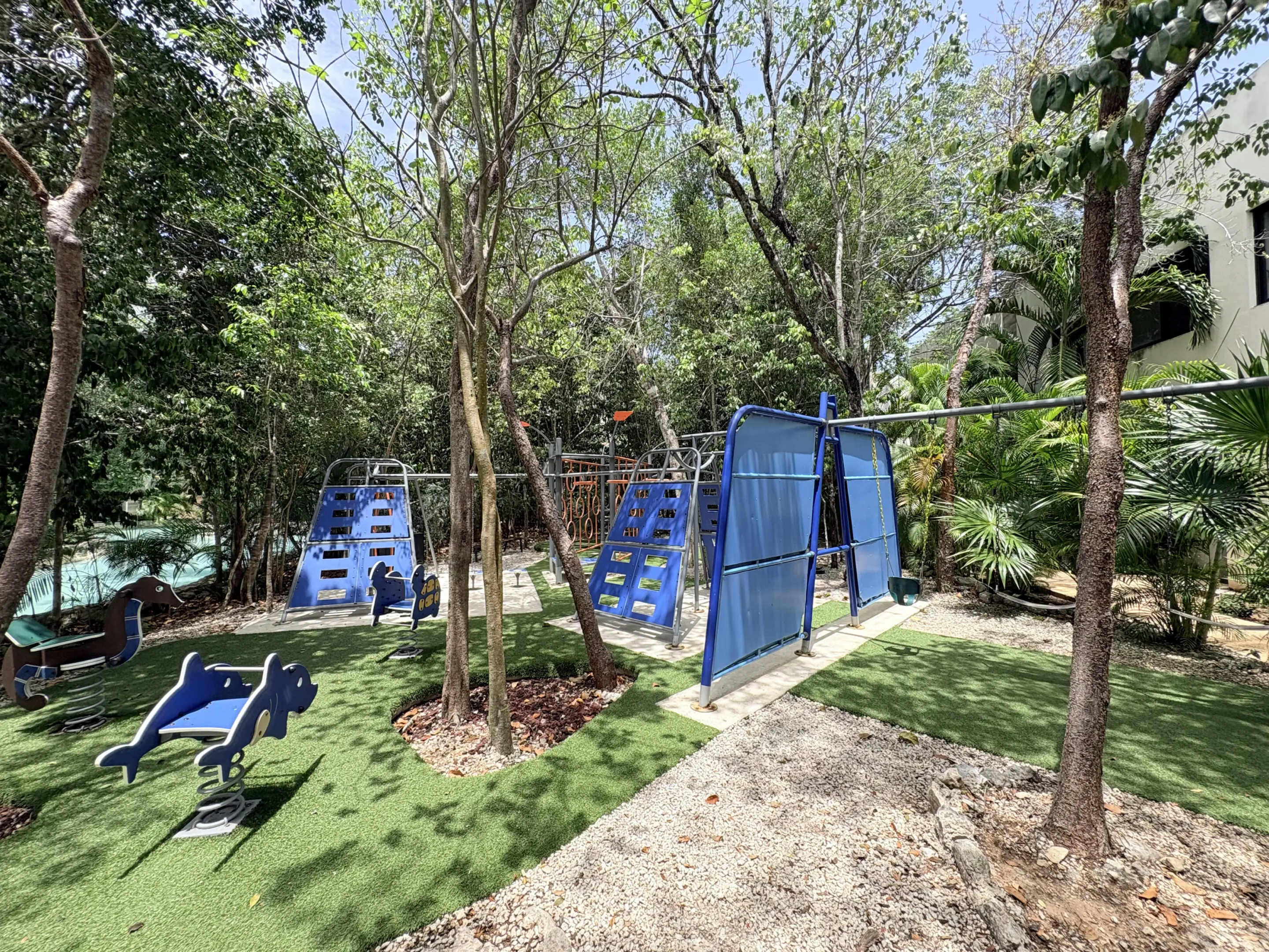 Shaded playground with blue climbing structures