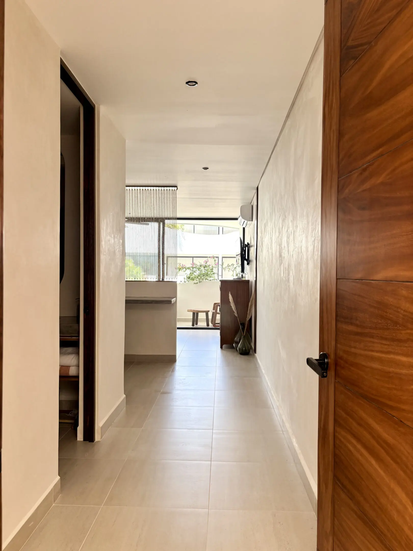 Minimalist hallway leading to bright living area