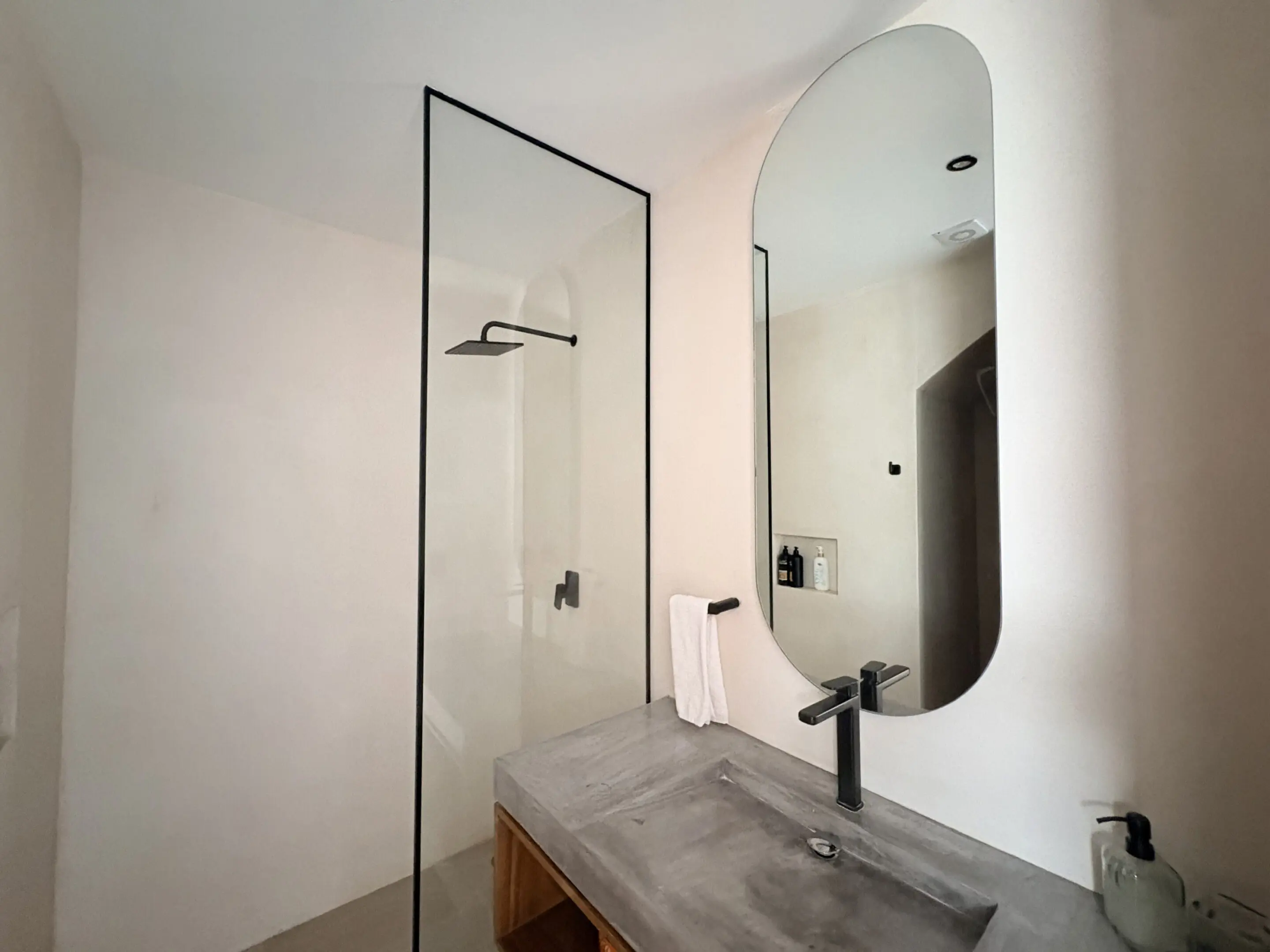 Minimalist bathroom with concrete vanity and glass shower