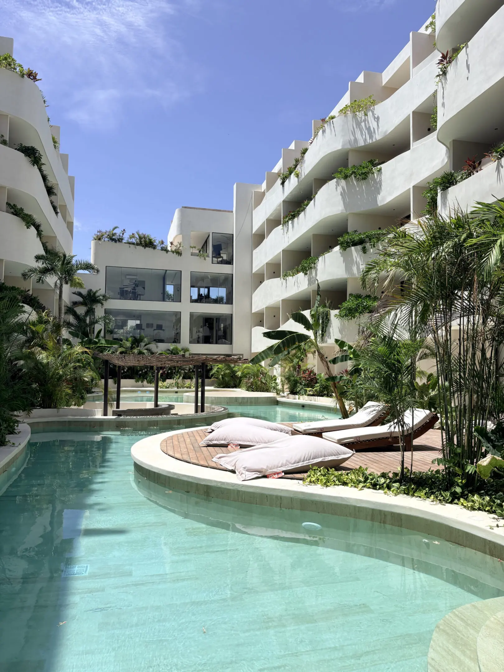 Curved resort pool with loungers and balconies
