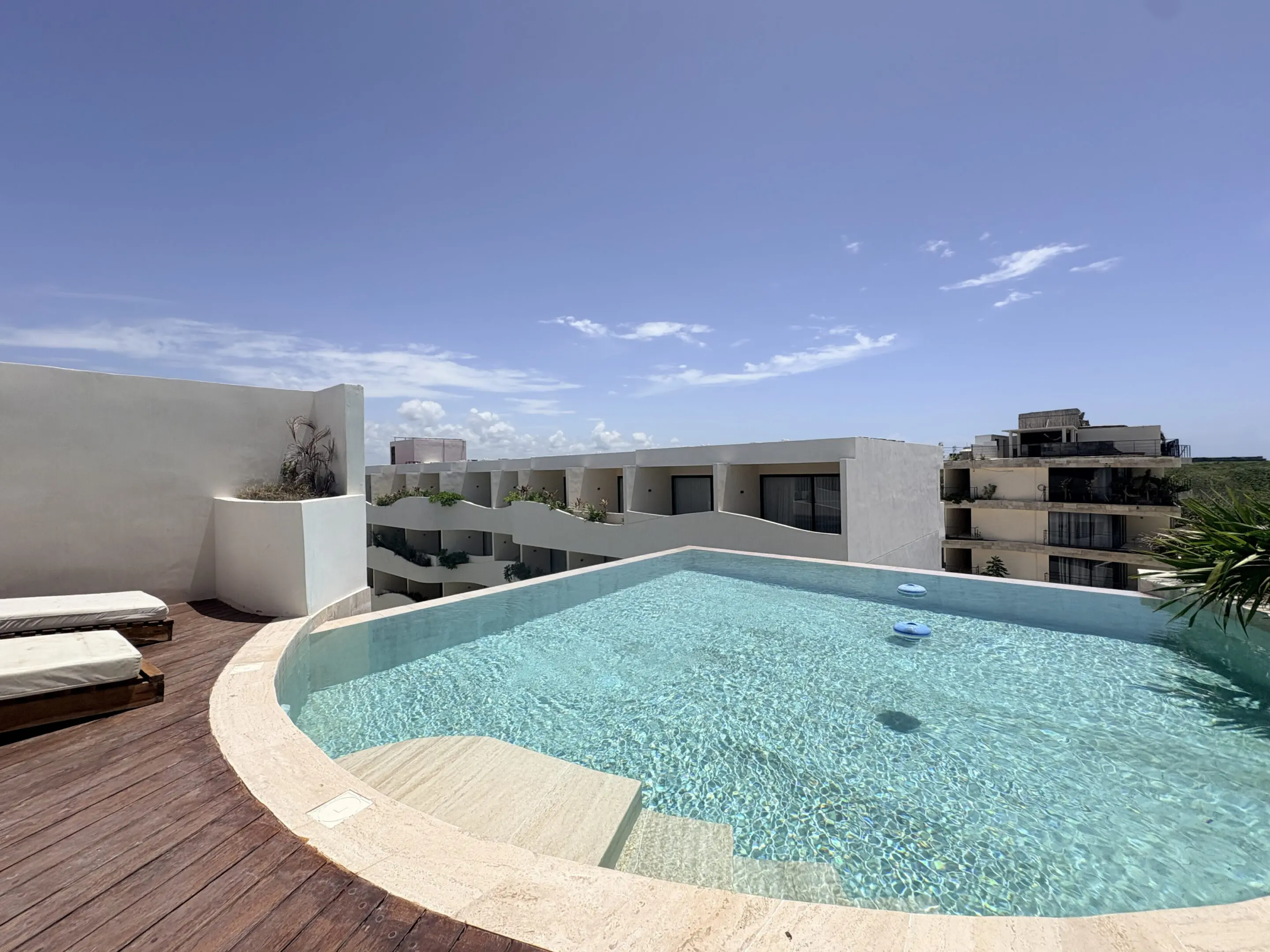 Rooftop infinity pool with lounge chairs