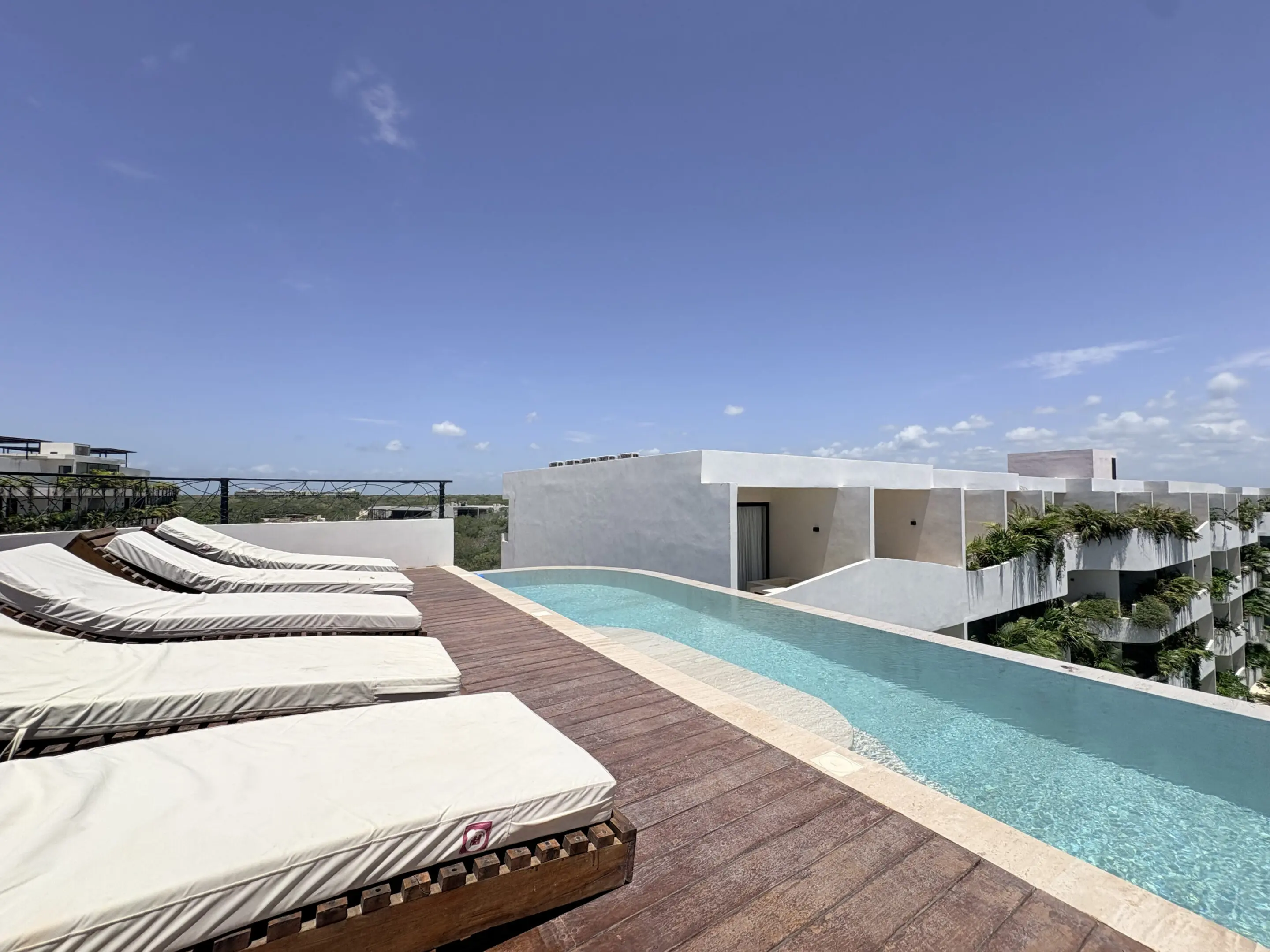 Modern rooftop infinity pool with lounge chairs
