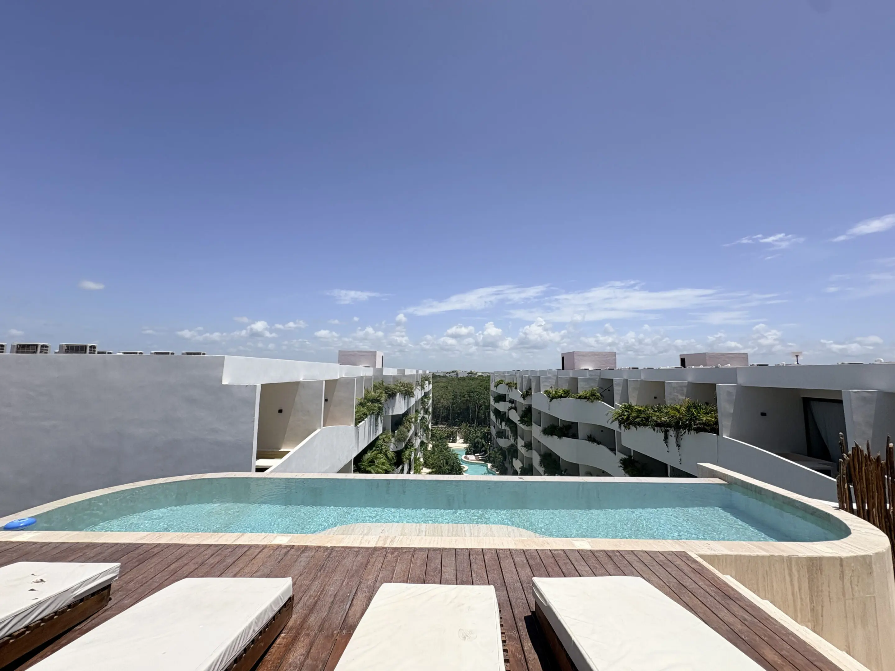 Rooftop infinity pool overlooking modern resort buildings