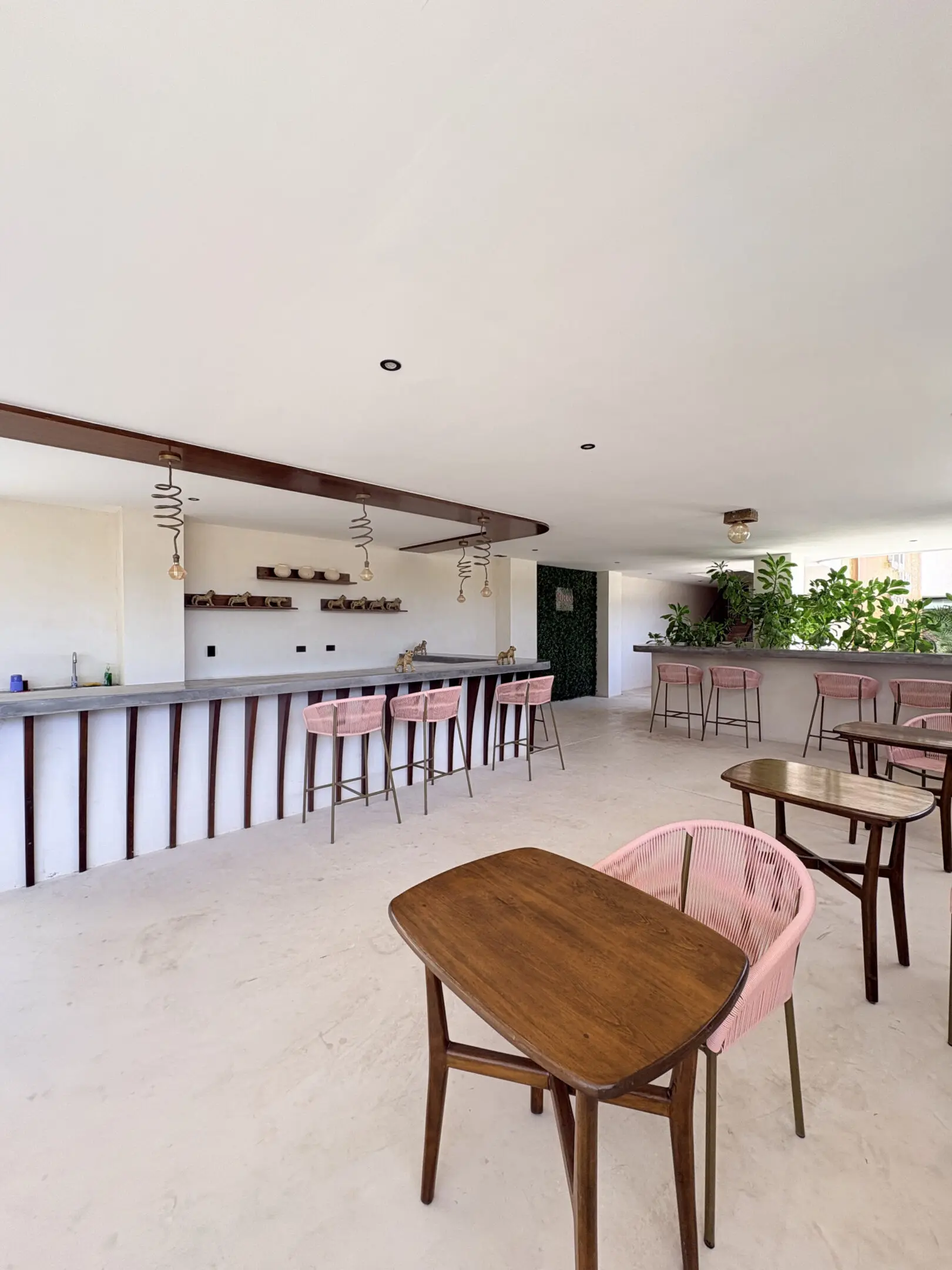 Bright minimalist bar area with pink chairs