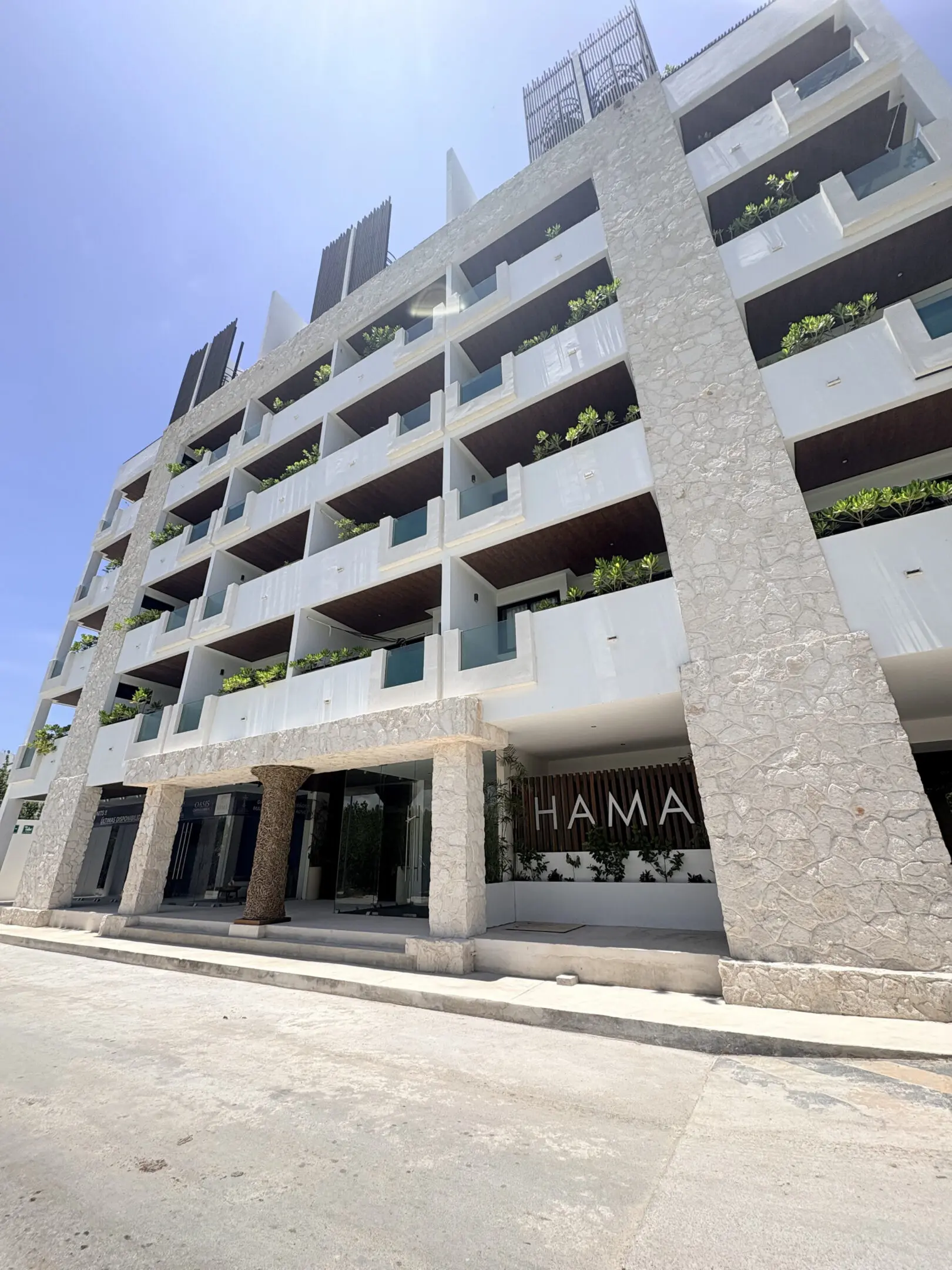 Modern multi-story building with balconies, stone facade