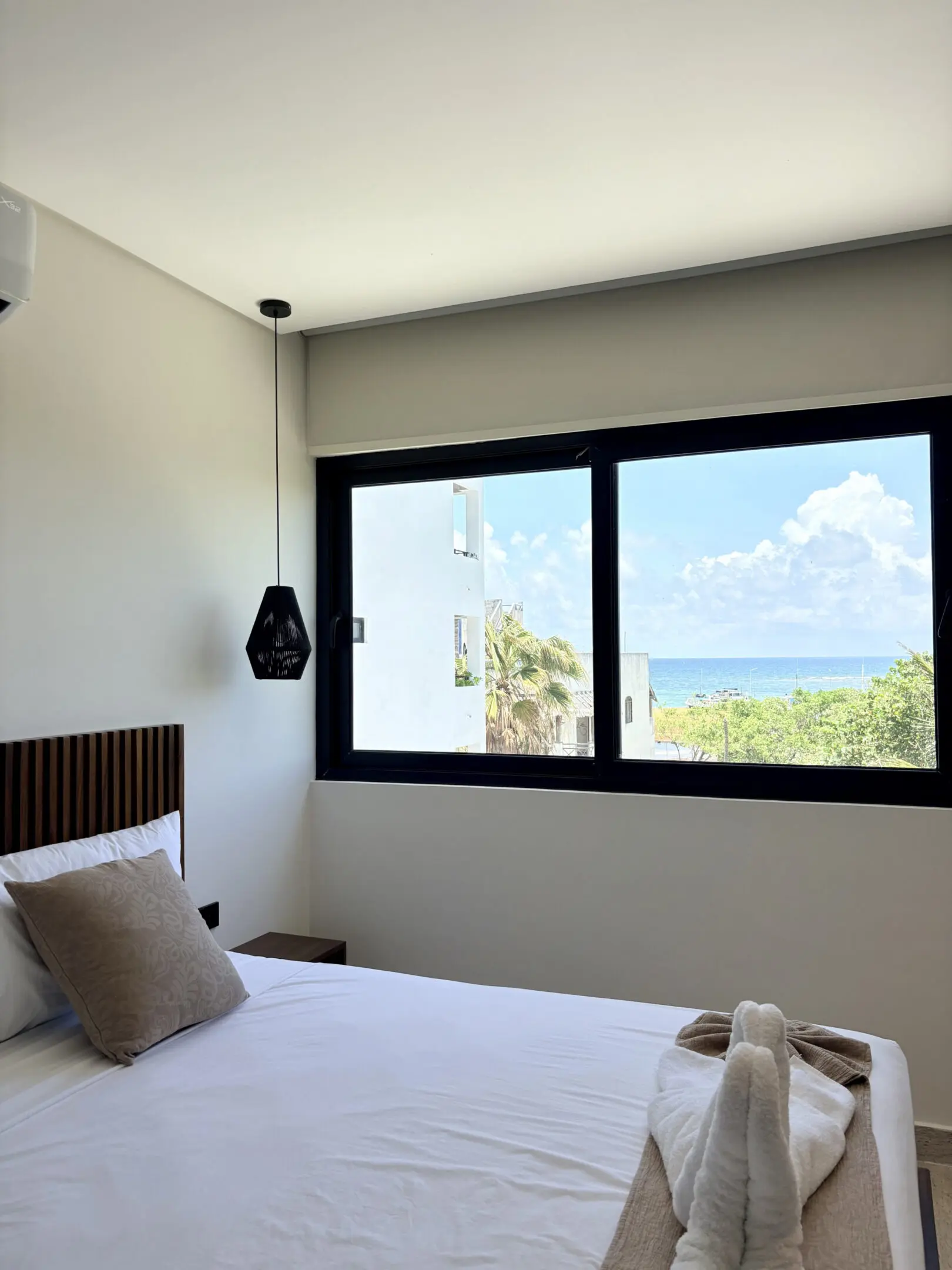 Modern beachside bedroom with towel swan