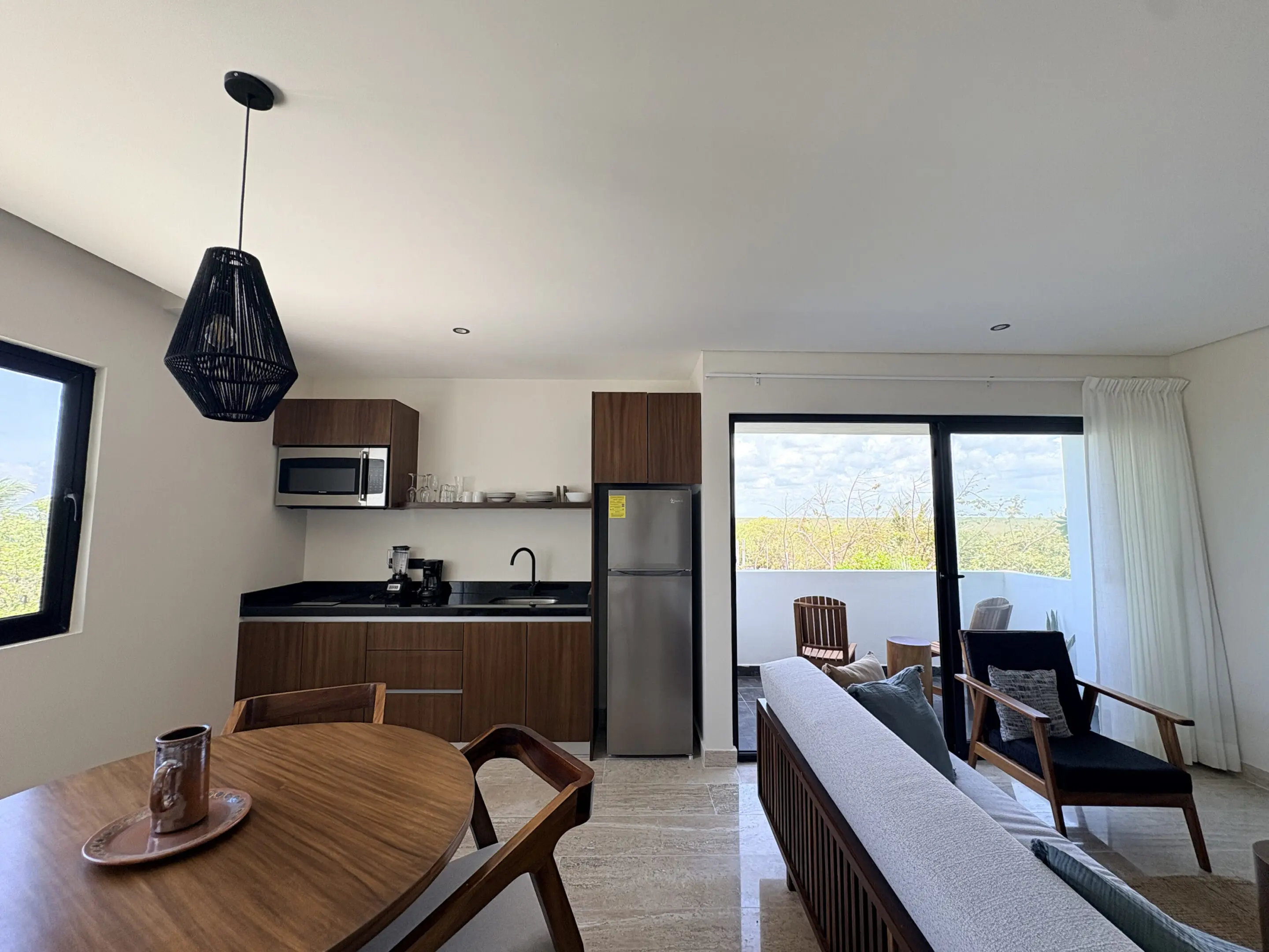 Modern open-plan living room with kitchenette and balcony