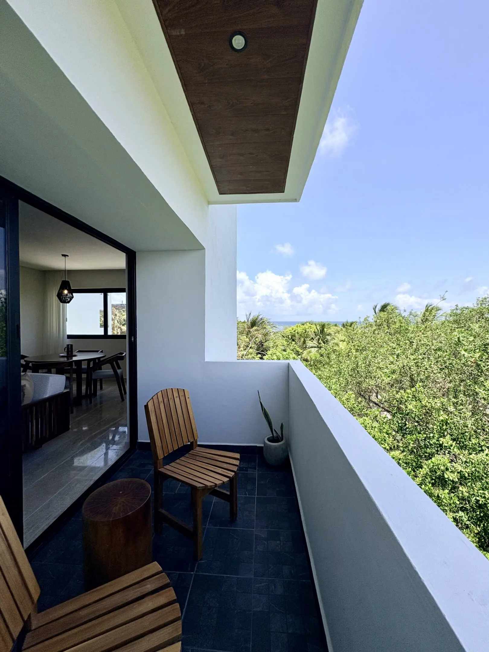 Balcony with wooden chairs overlooking treetops