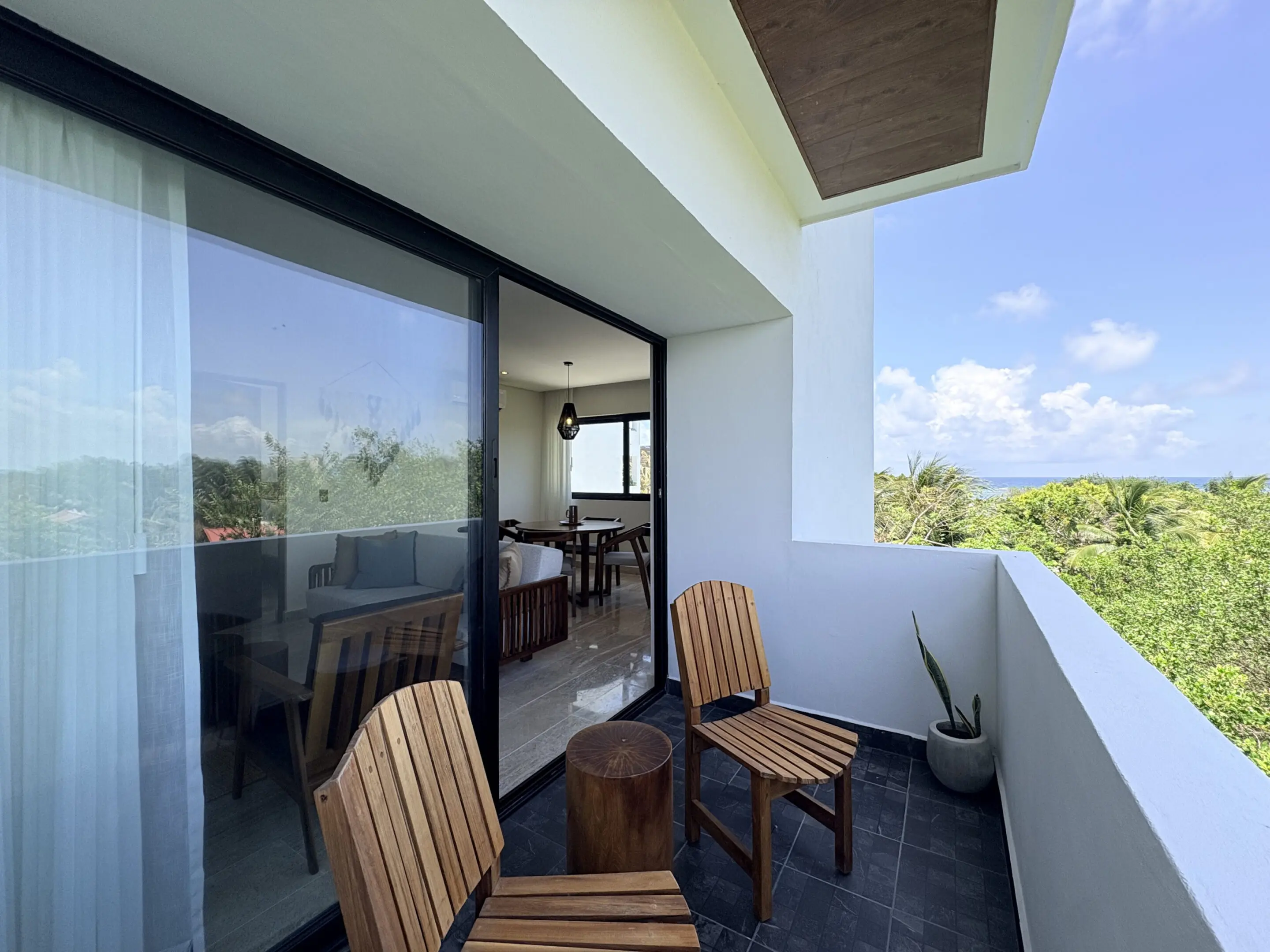 Modern balcony with wooden chairs and greenery