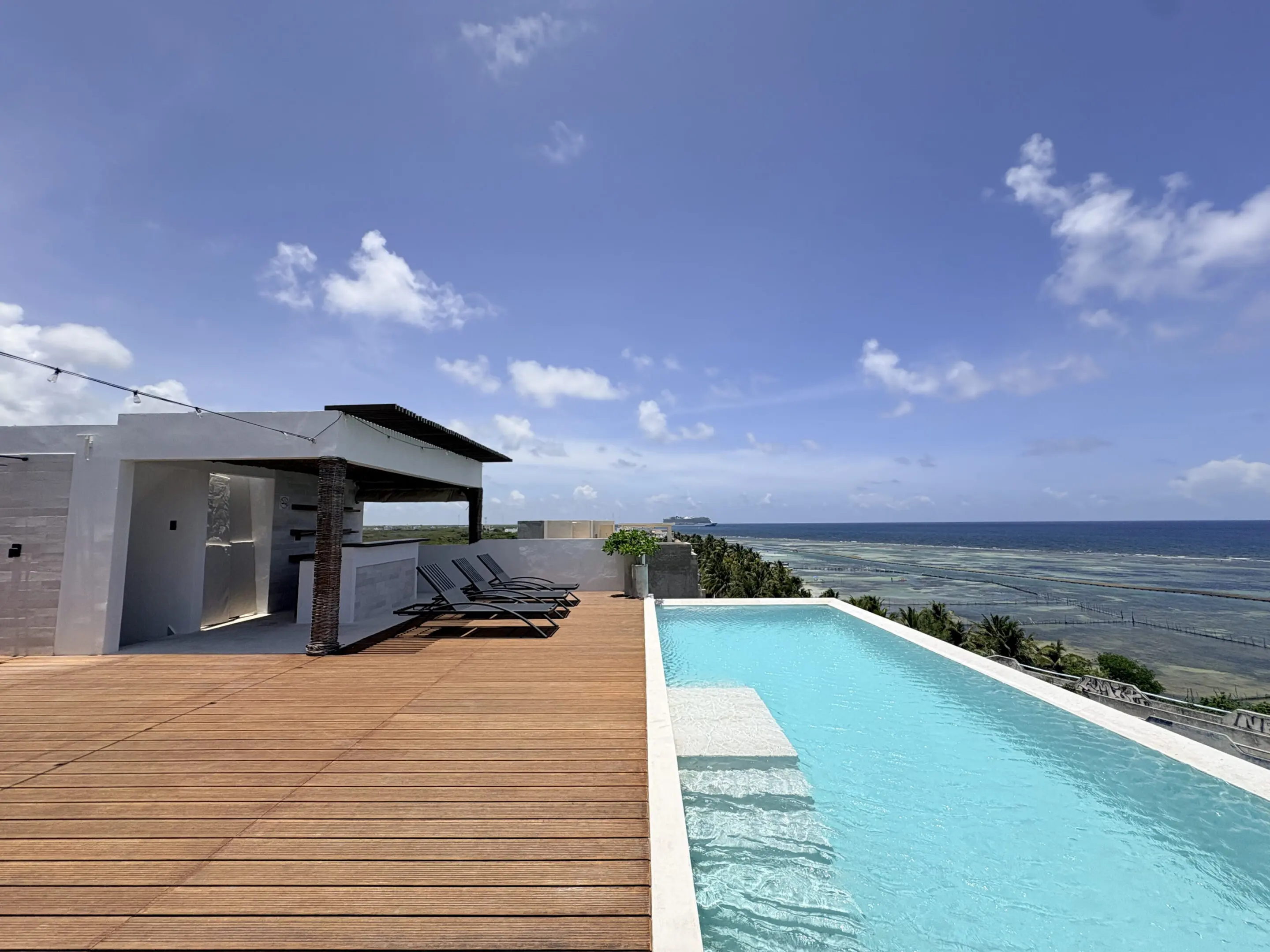 Ocean-view rooftop infinity pool with lounge chairs