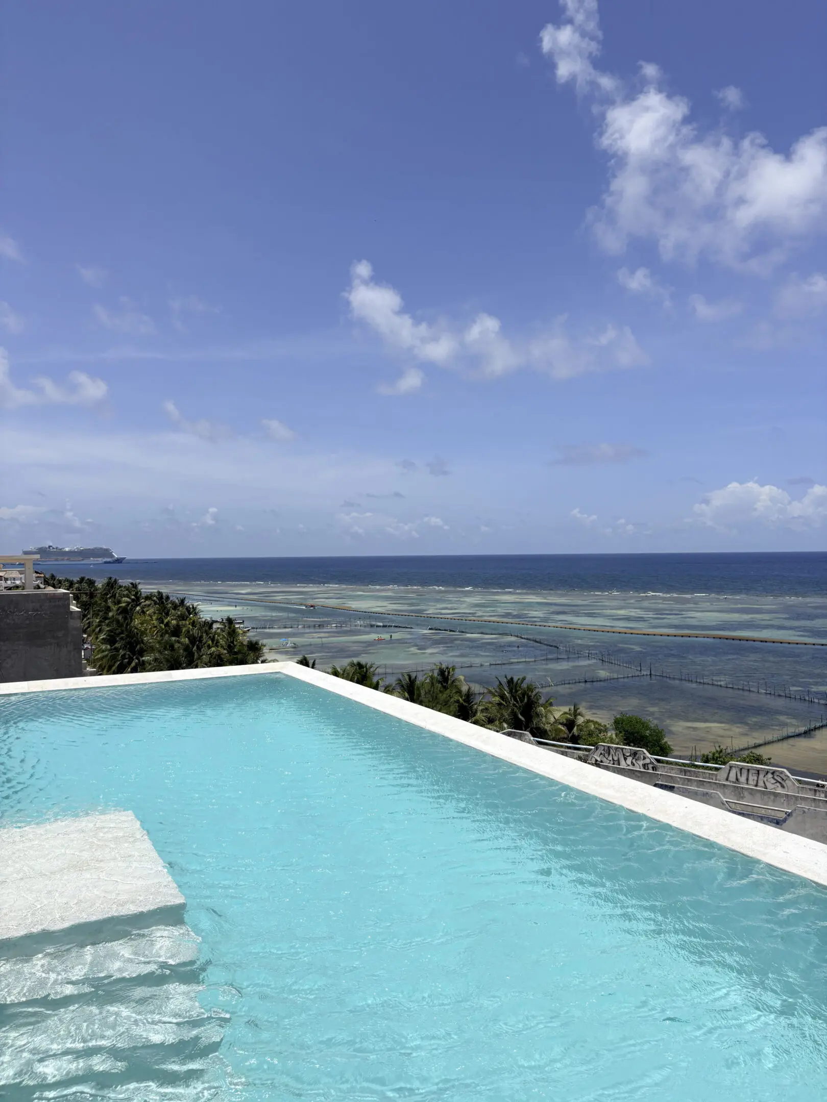 Infinity pool overlooking turquoise ocean and coastline