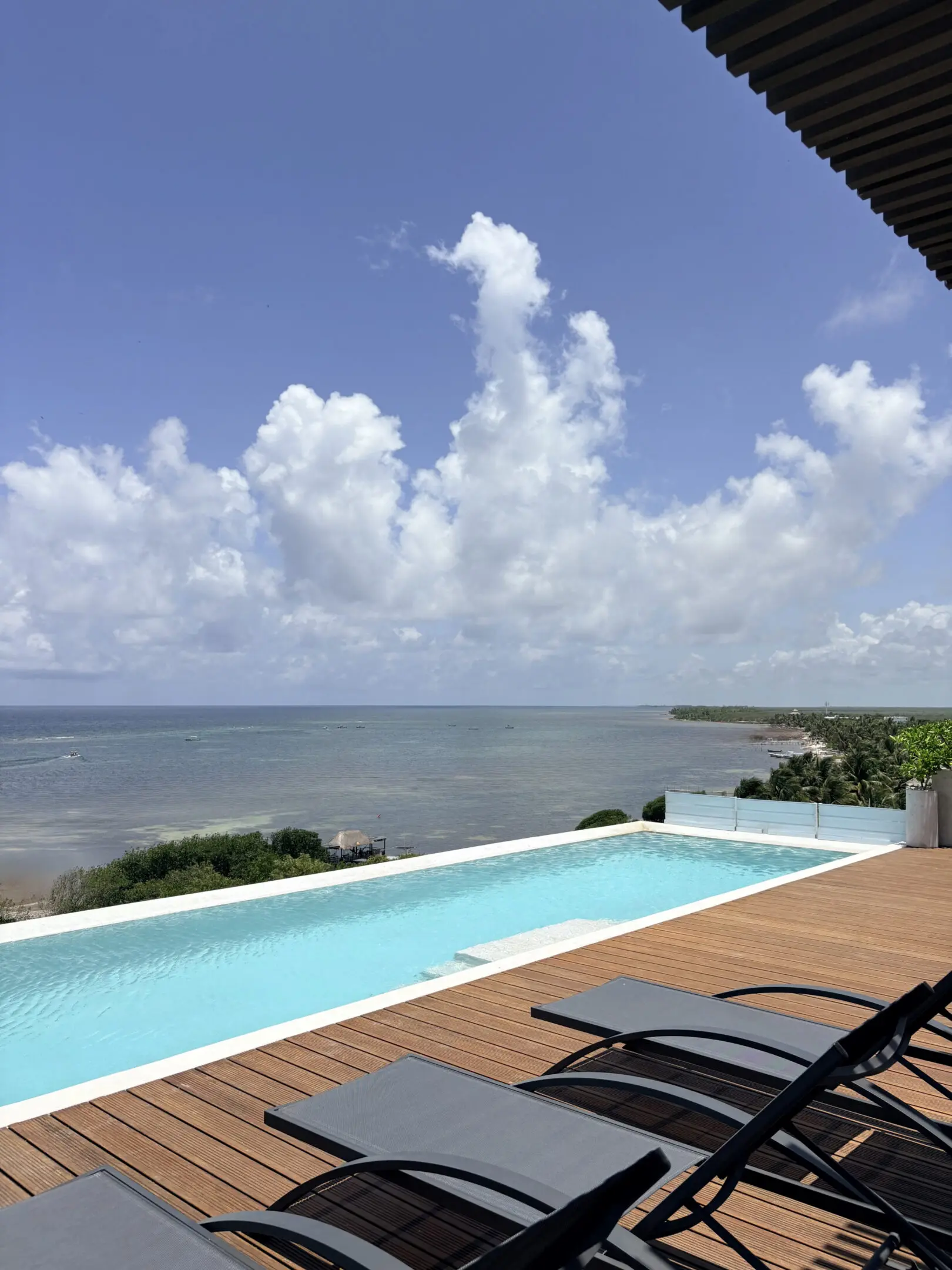 Infinity pool terrace overlooking ocean with loungers