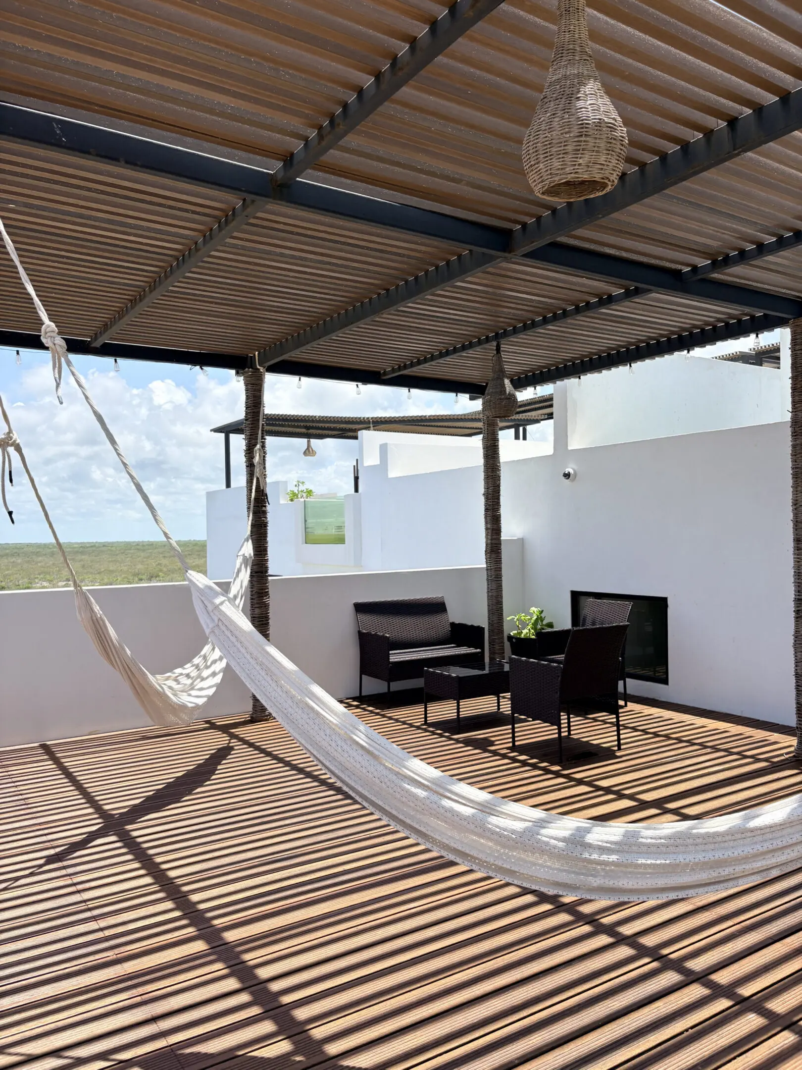 Sunlit rooftop terrace with hammock and seating
