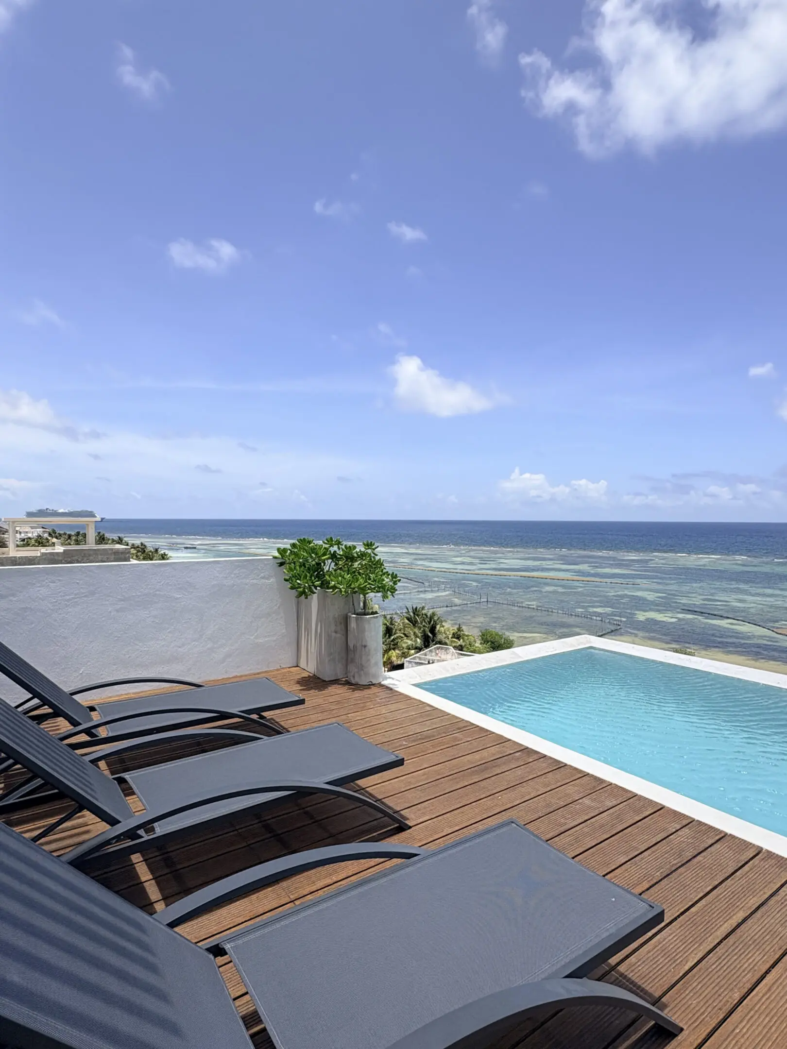 Pool deck with loungers overlooking ocean