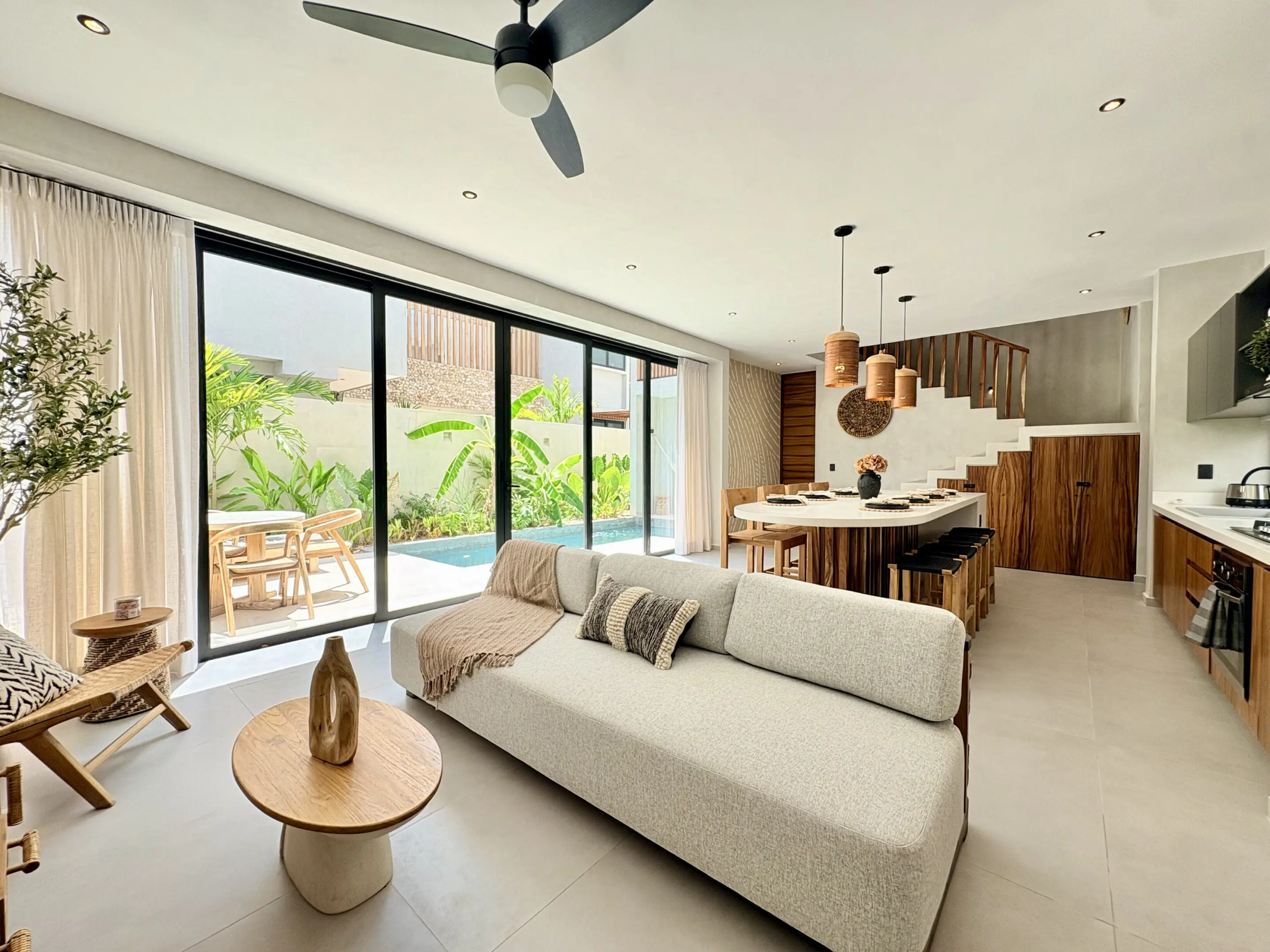 Open-plan living area with pool-view glass doors