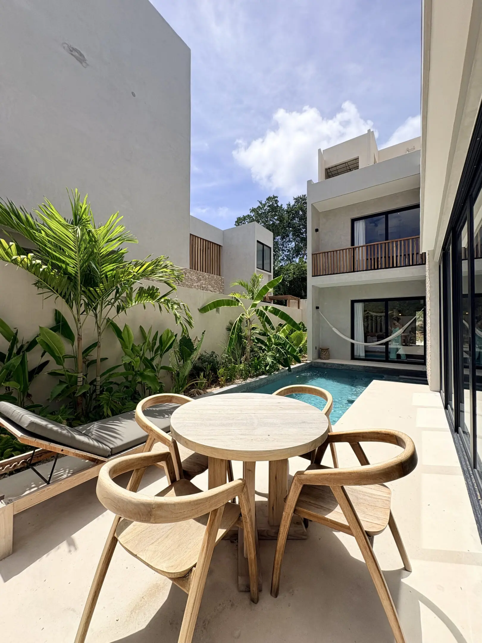 Modern villa patio with pool and wooden table