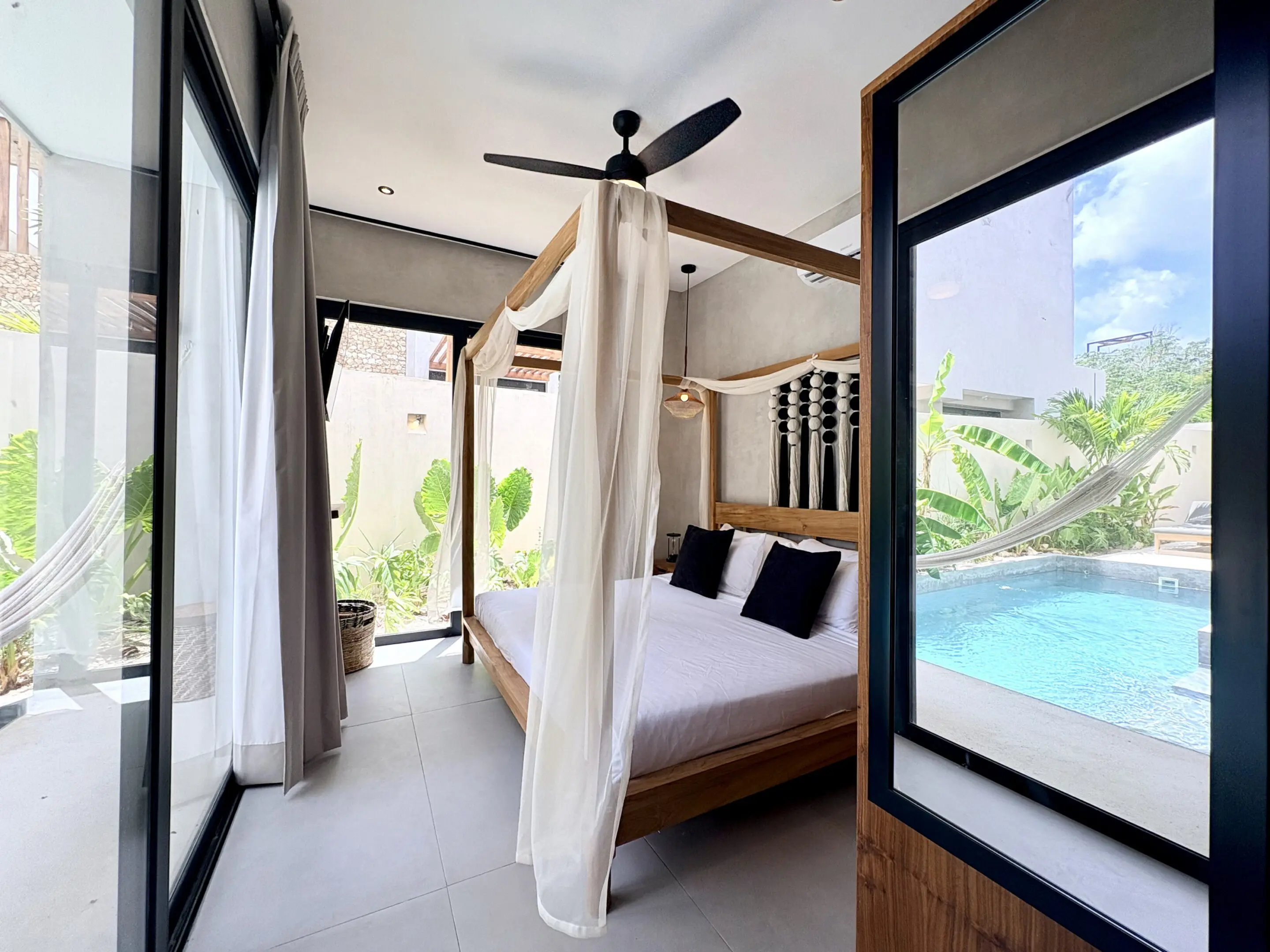 Tropical bedroom with canopy bed and pool