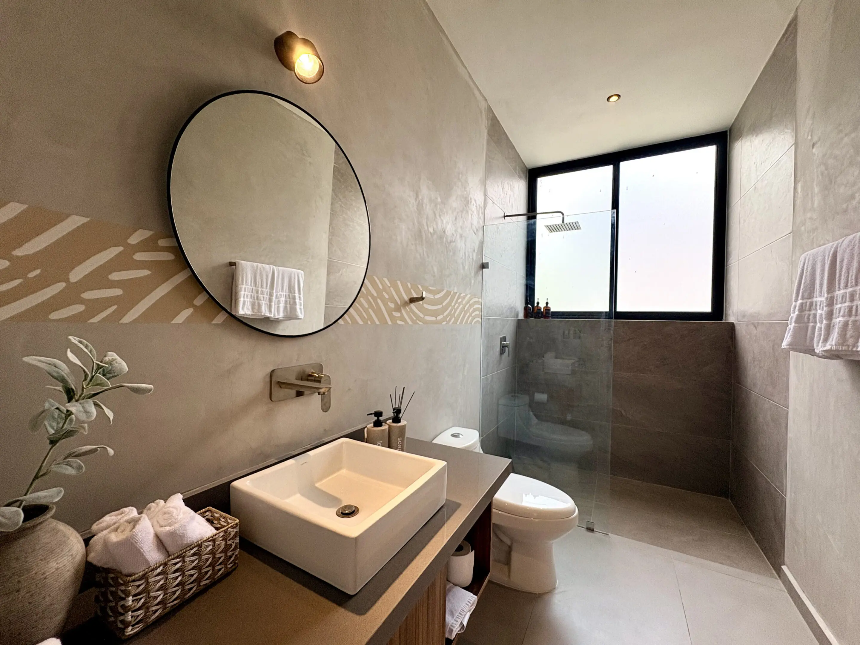 Modern bathroom with round mirror and shower