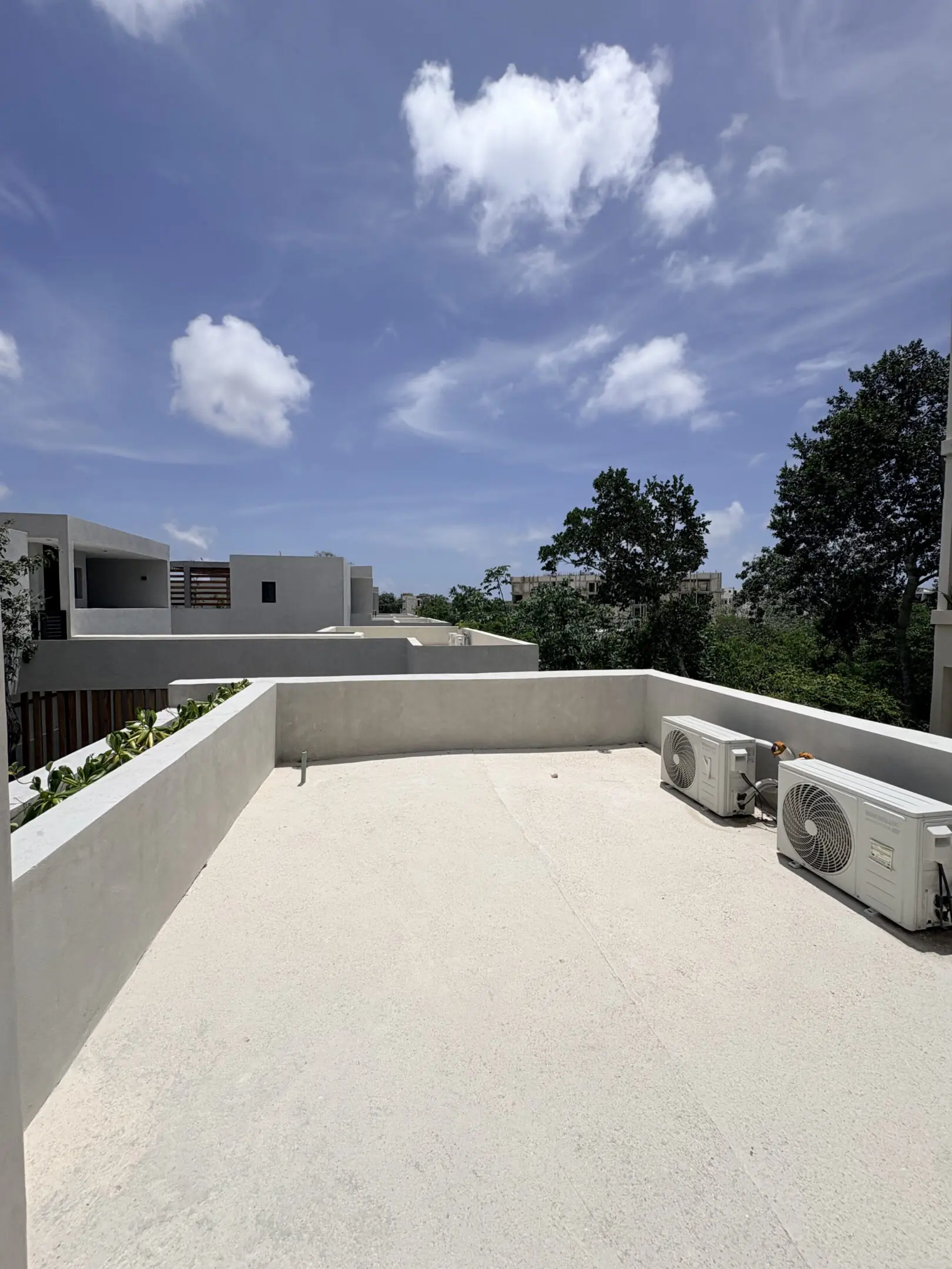 Rooftop terrace with AC units and blue sky