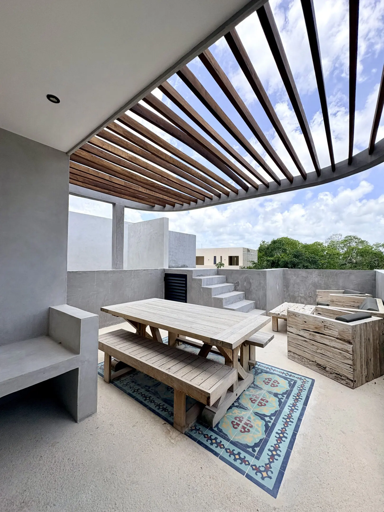 Modern rooftop patio with wooden pergola and seating