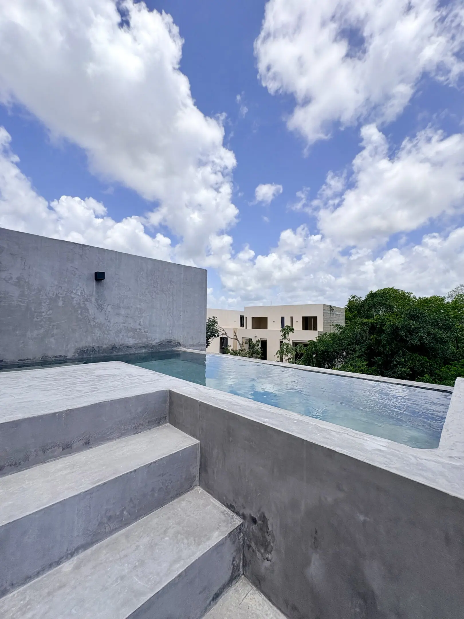 Rooftop concrete infinity pool under blue sky