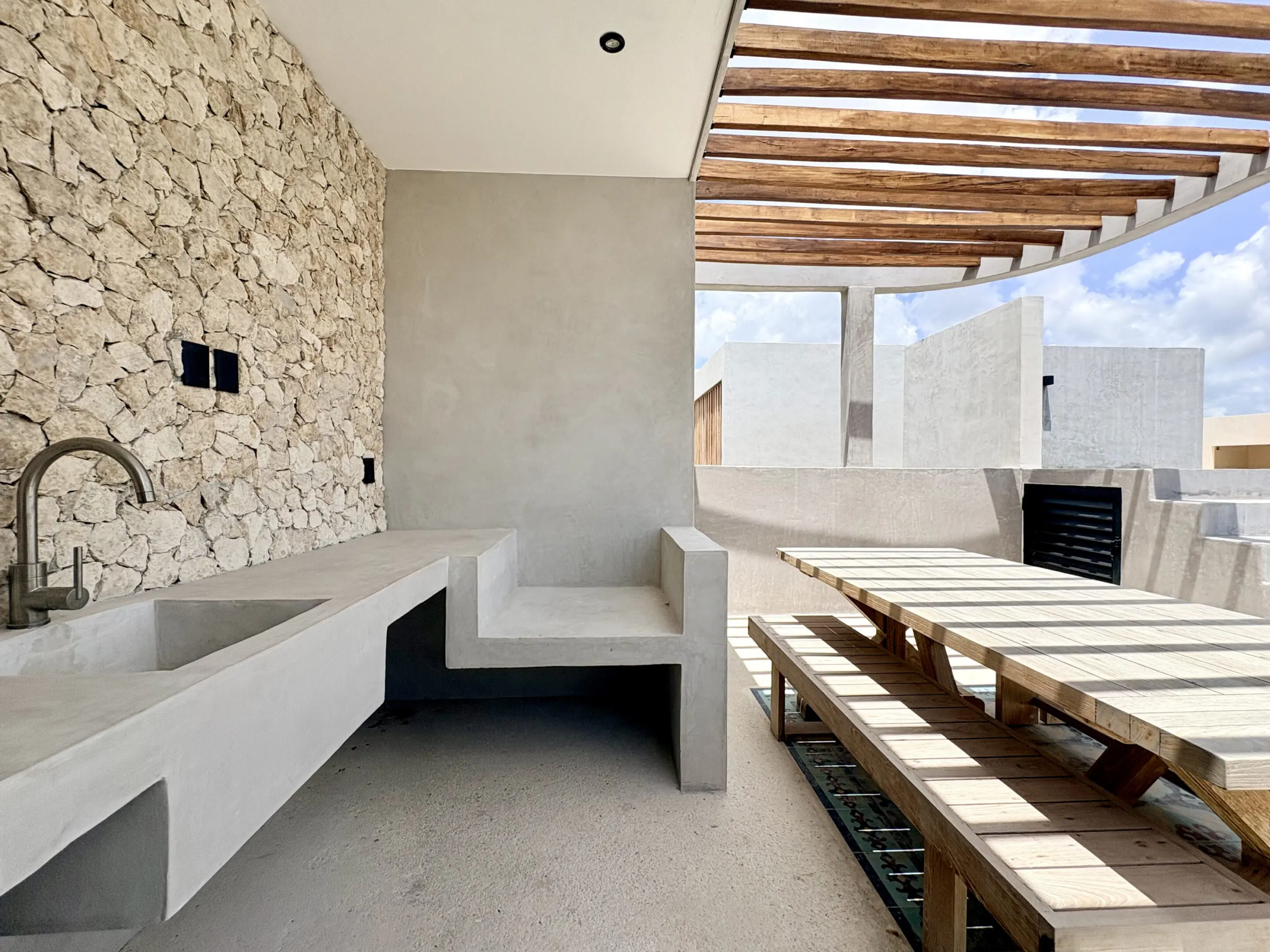 Modern outdoor concrete kitchen and dining area