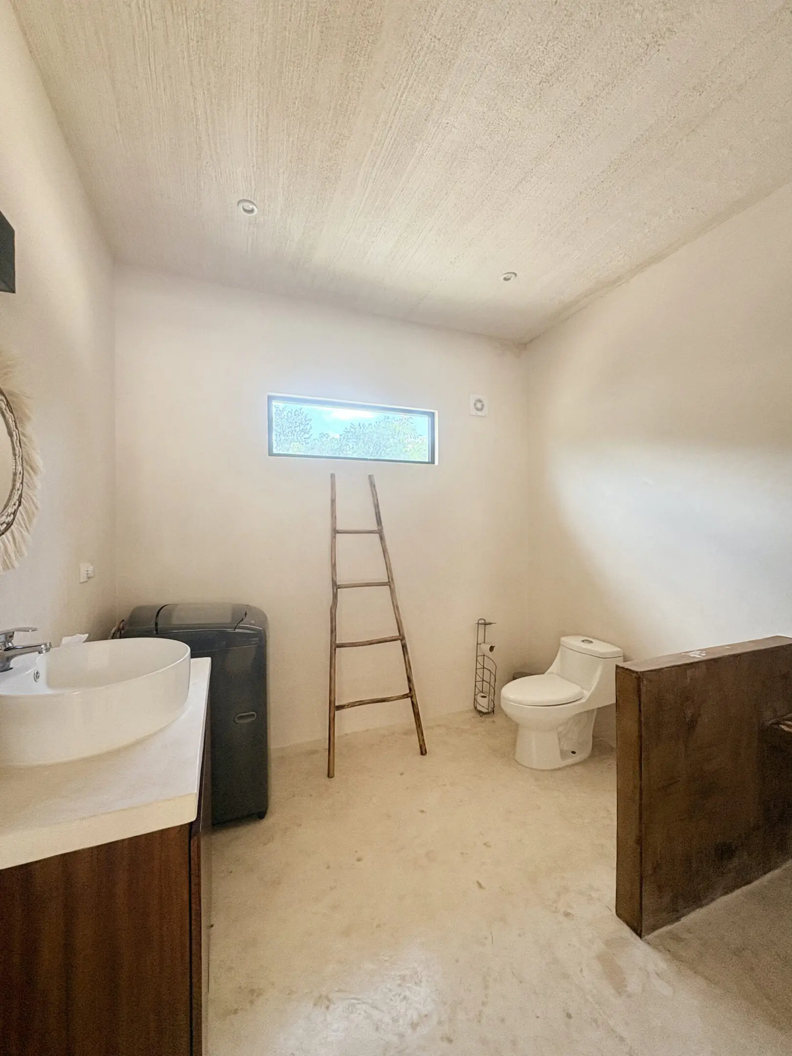 Minimalist bathroom with ladder, sink, and toilet