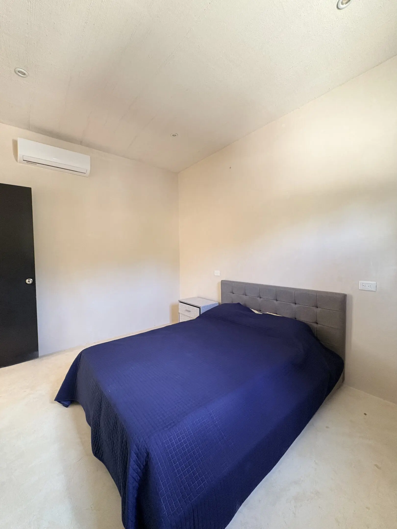Minimalist bedroom with navy blue bedspread