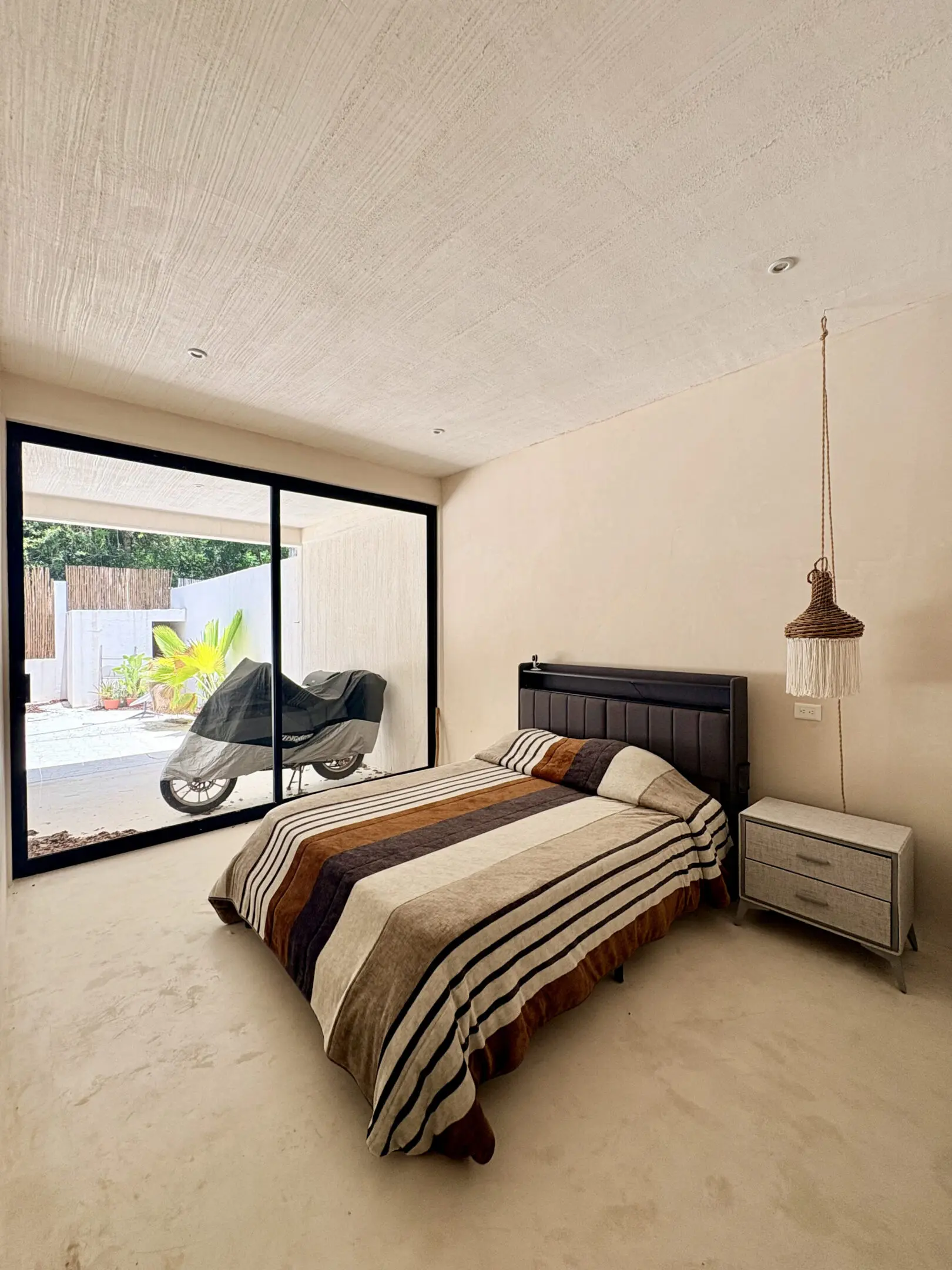 Minimalist bedroom with striped bed and sliding door
