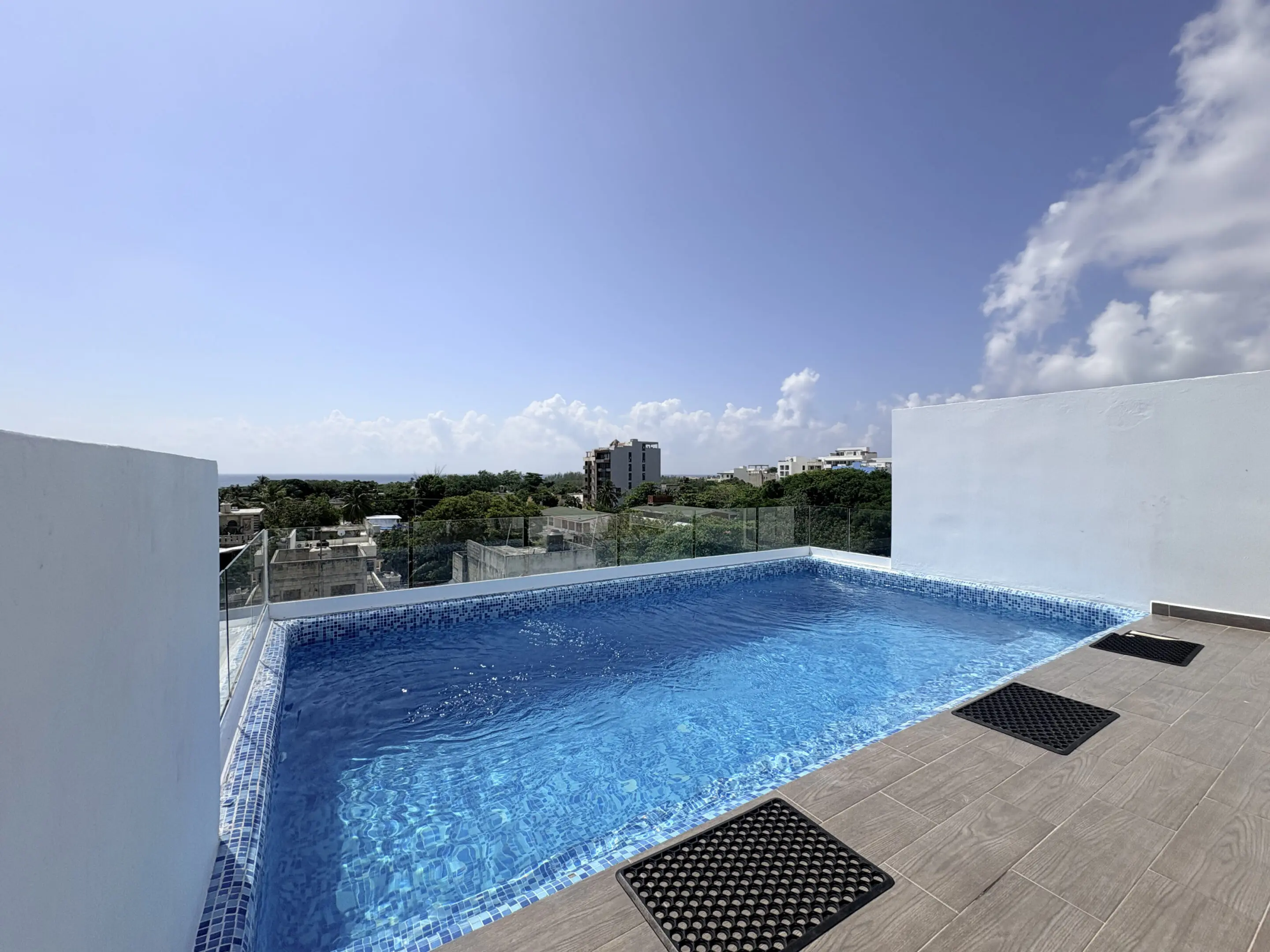 Rooftop pool with city skyline and blue sky