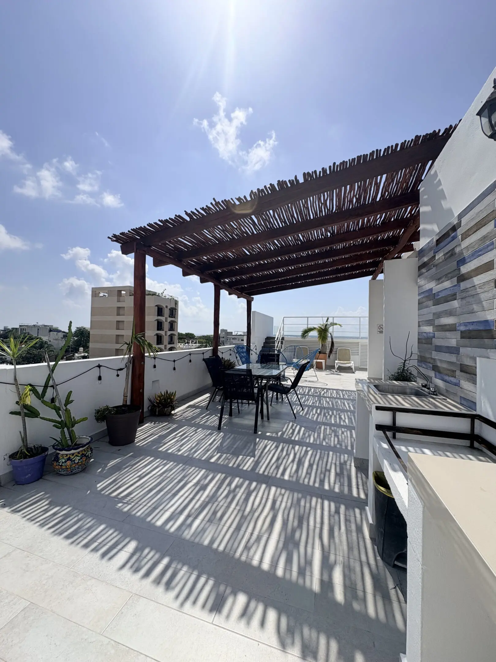 Sunlit rooftop terrace with pergola and seating