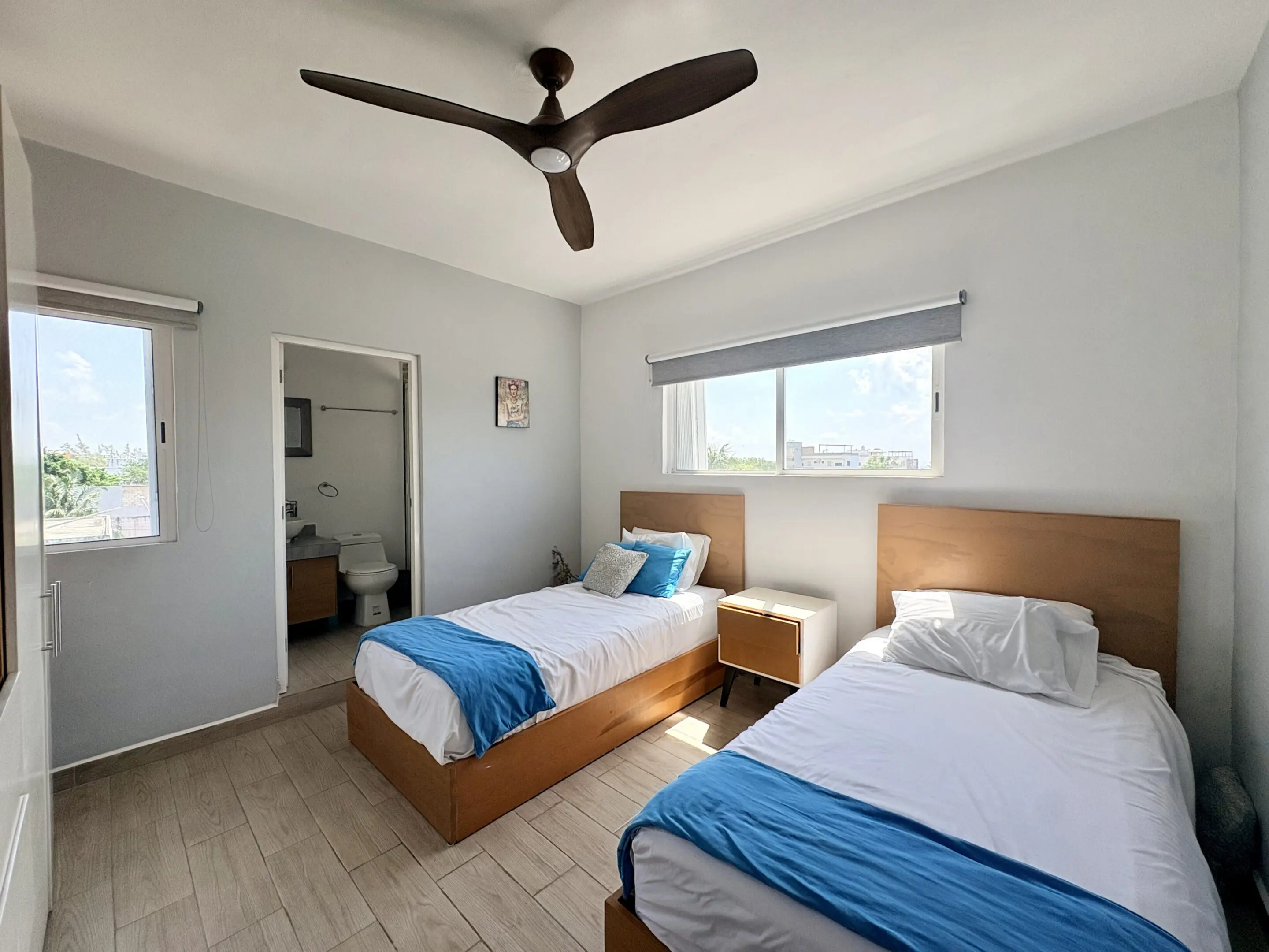Sunlit twin bedroom with blue accents