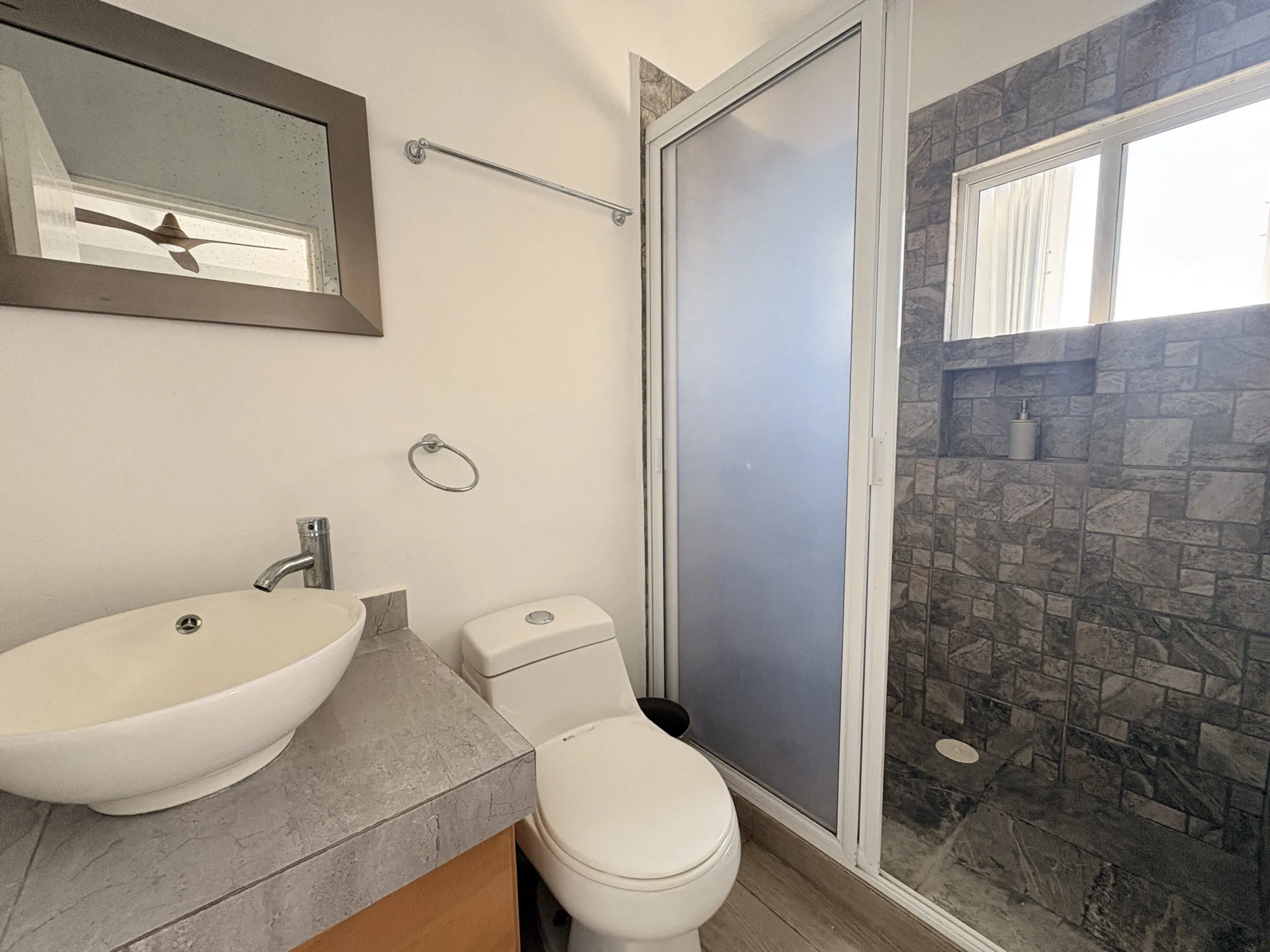 Bathroom with vessel sink, toilet, and shower