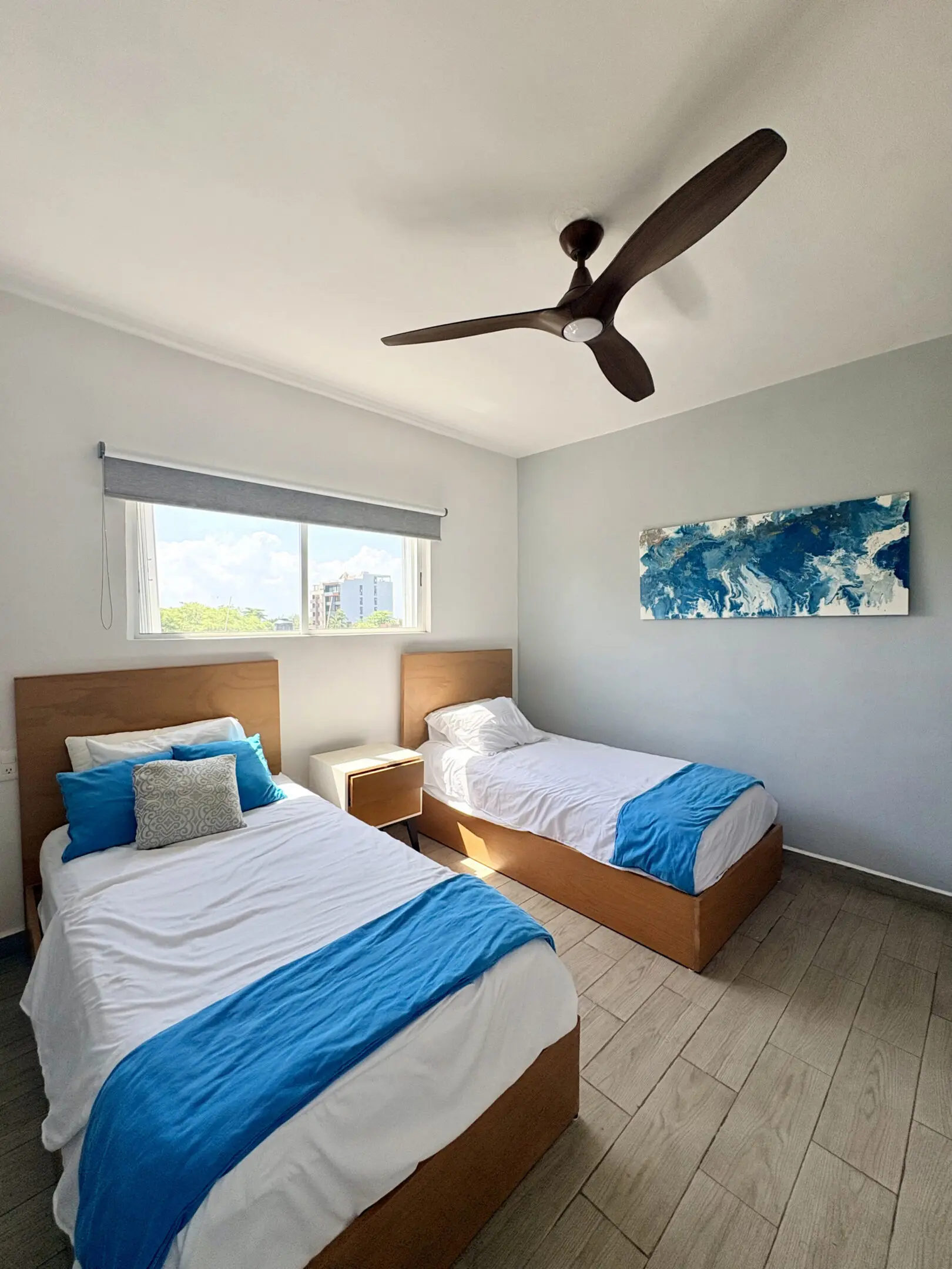 Twin beds with blue linens in modern bedroom