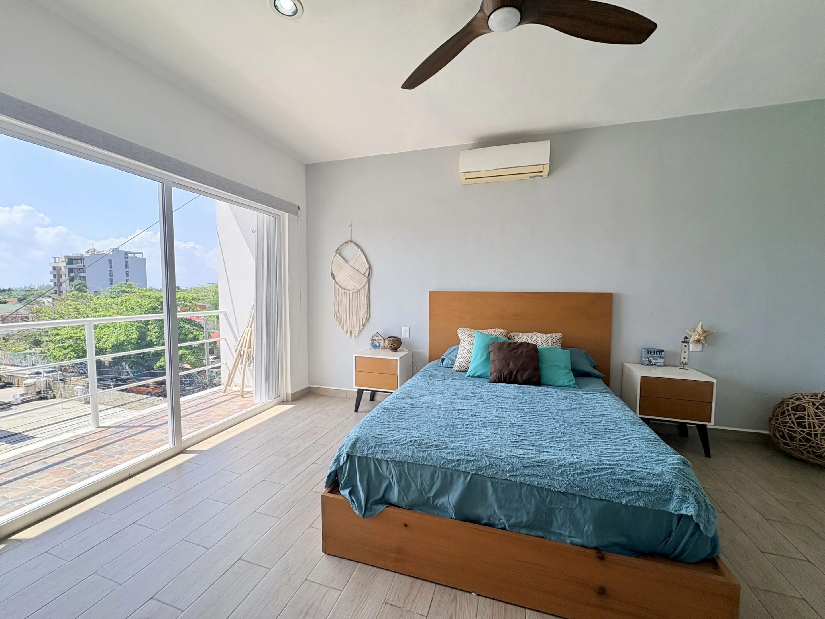 Sunlit modern bedroom with teal bedding