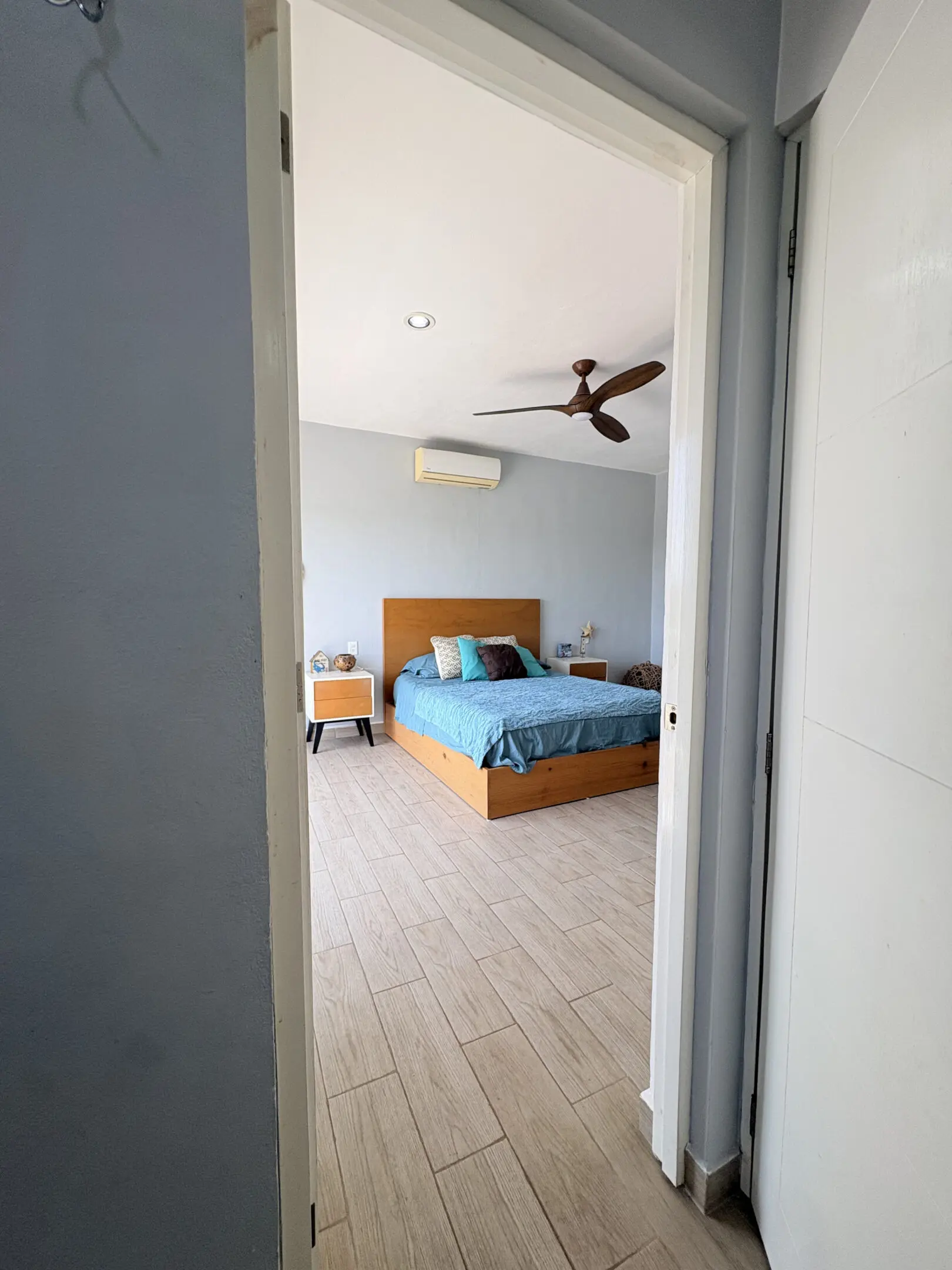 Doorway view into modern bedroom with blue bedding