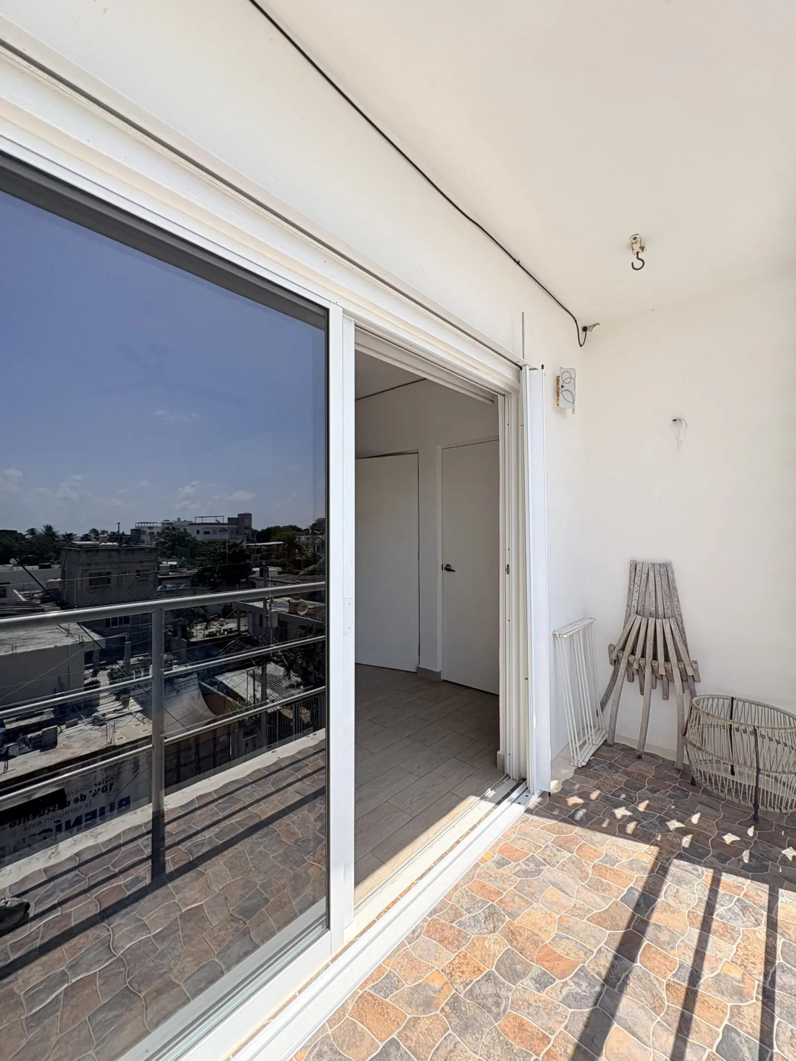 Sunlit balcony with sliding glass door