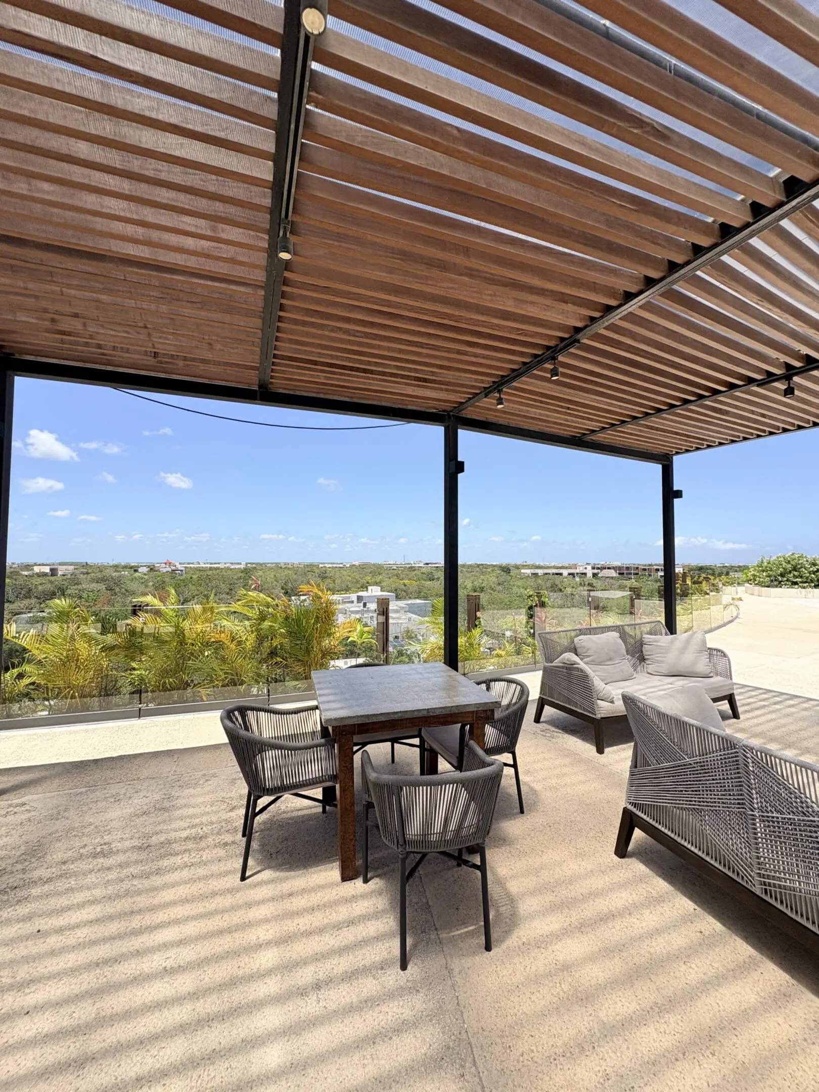 Pergola patio overlooking greenery with table seating