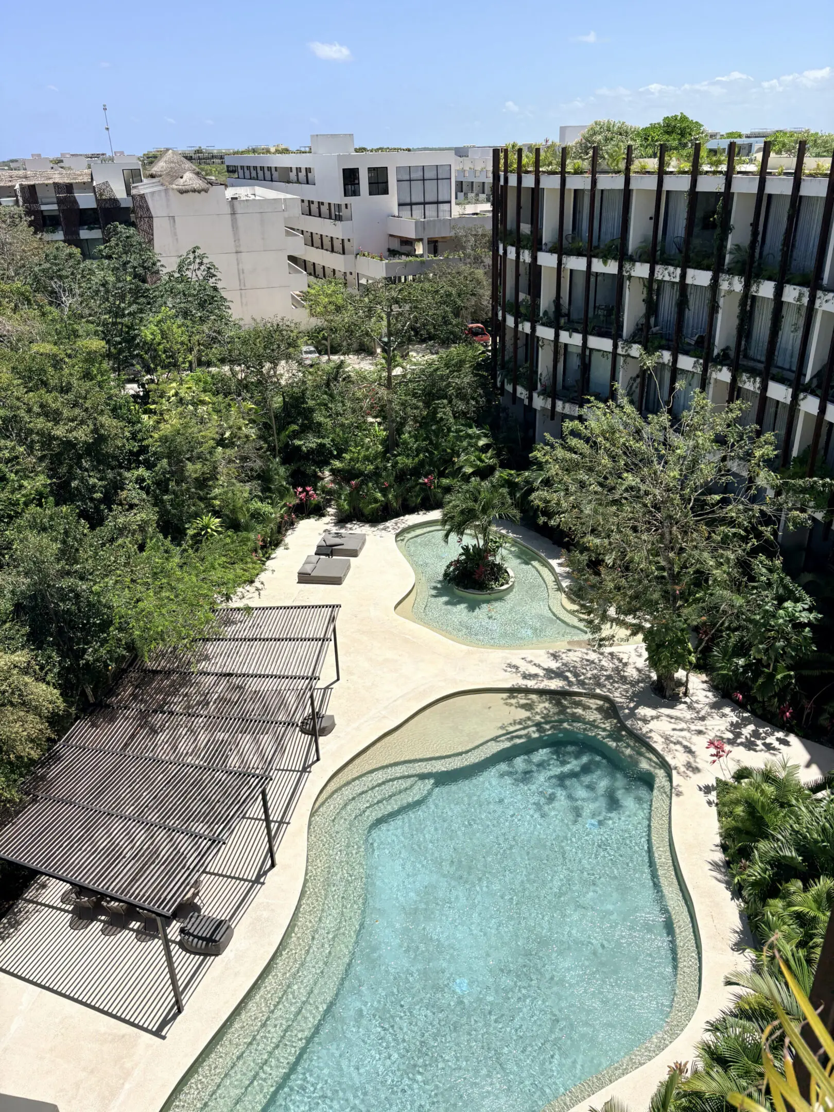 Curved outdoor pool with lounge pergola