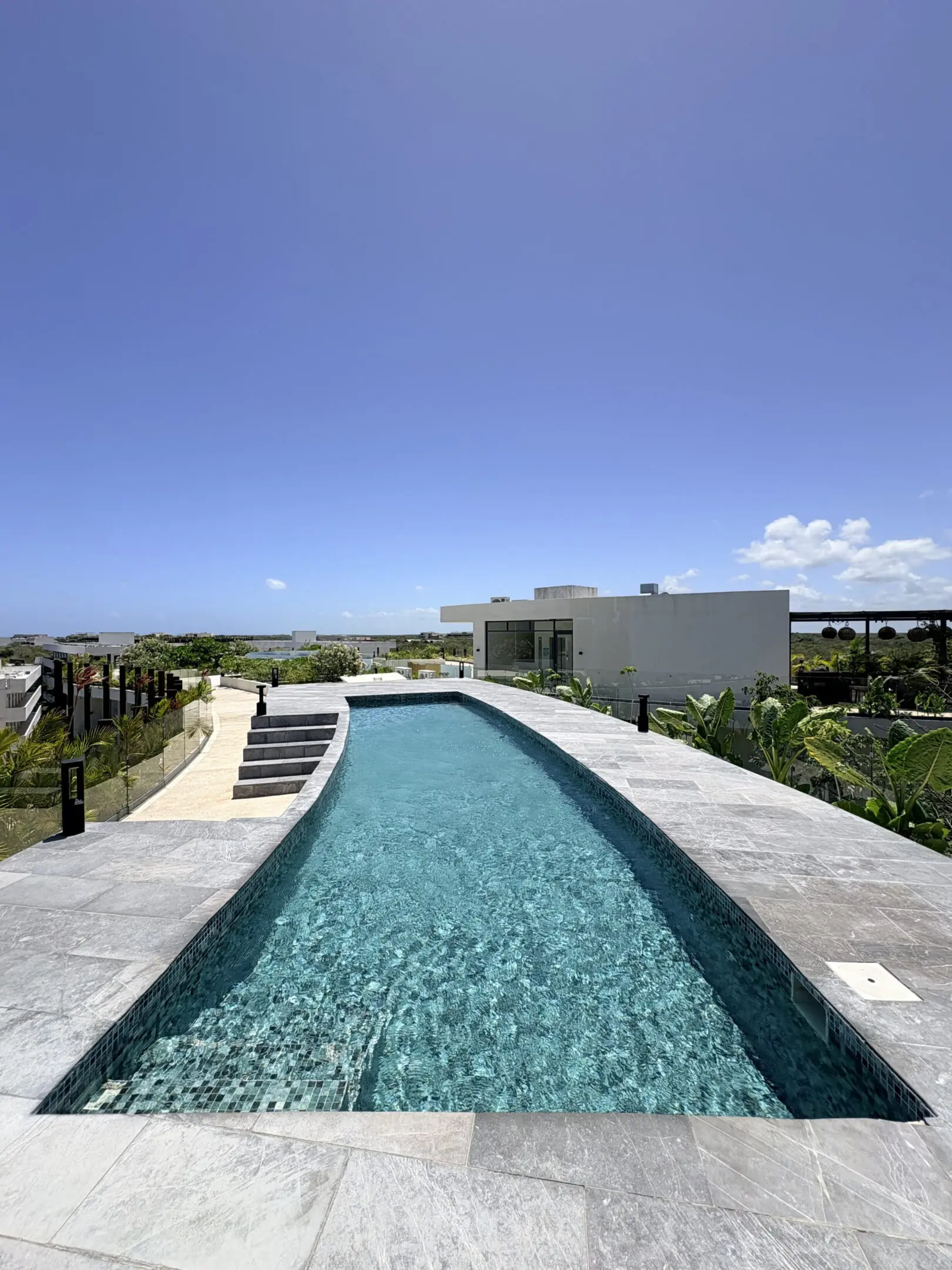 Long rooftop pool overlooking modern house and landscape