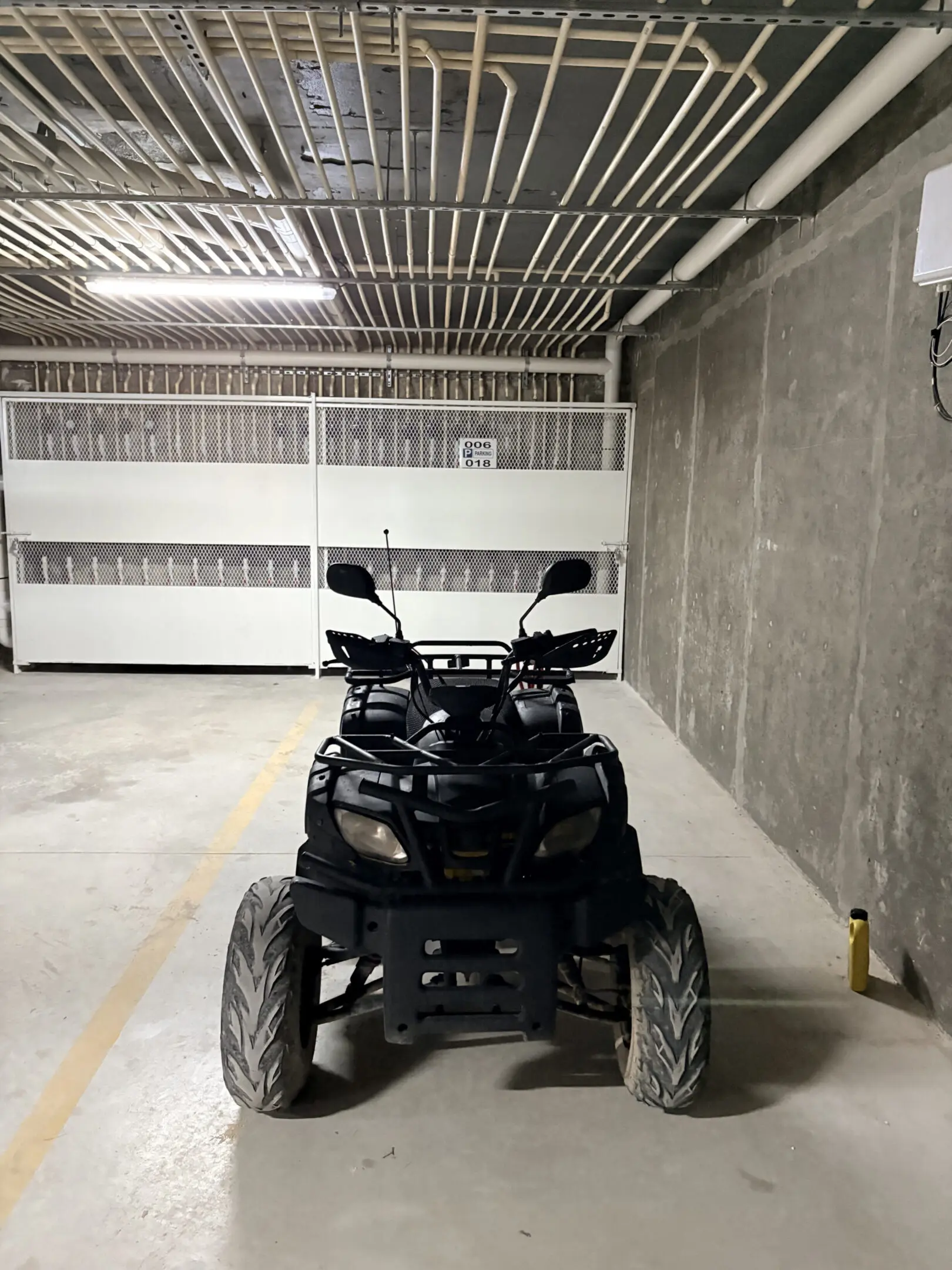 Black ATV parked in underground concrete garage