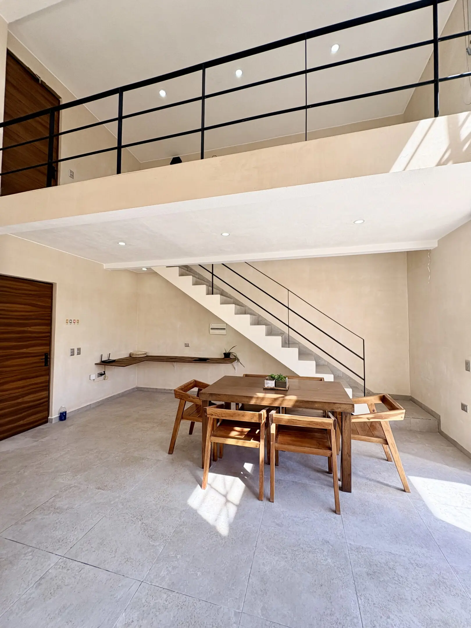 Modern dining area with staircase and mezzanine