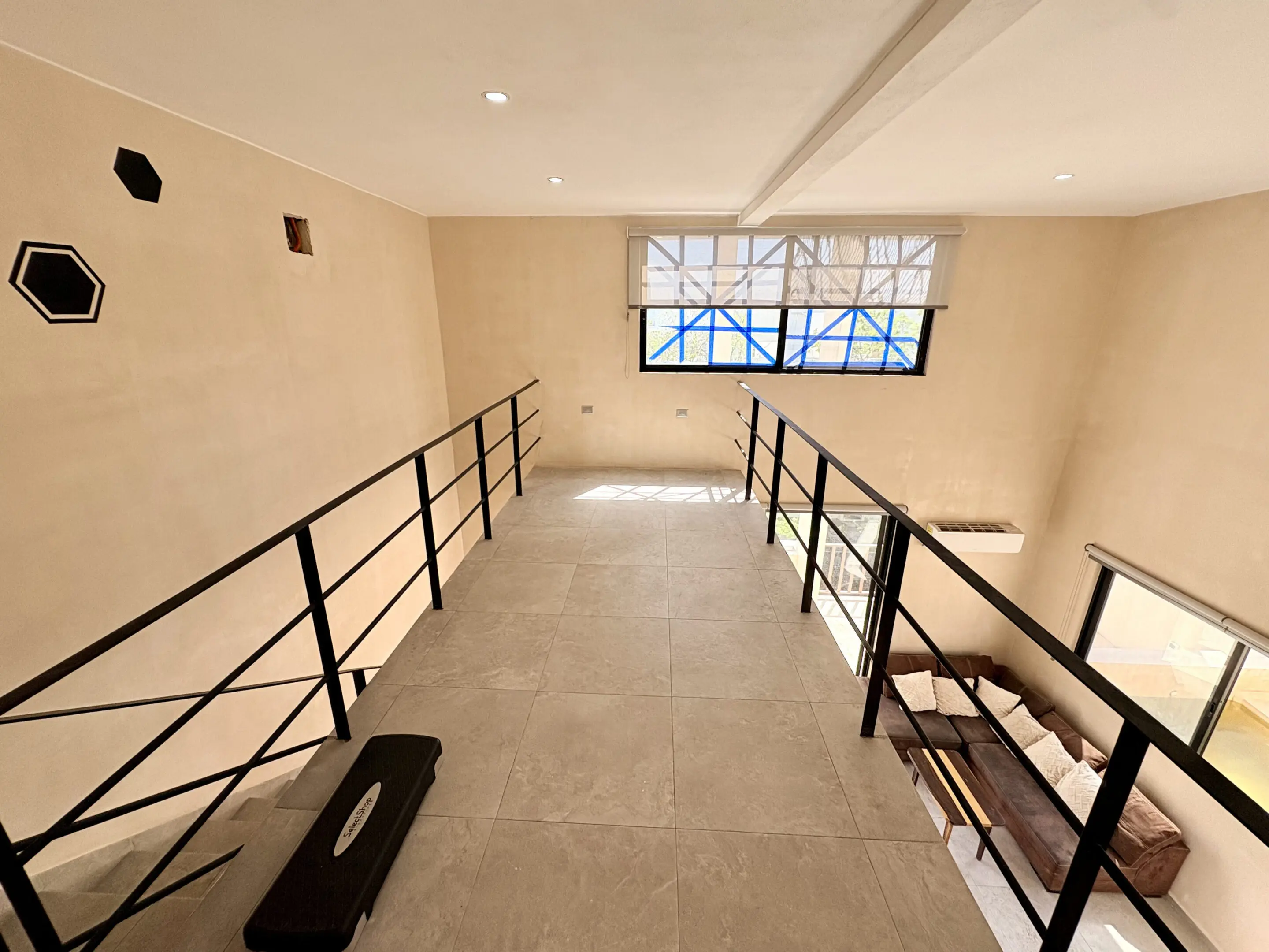 Mezzanine loft with metal railings and sofa