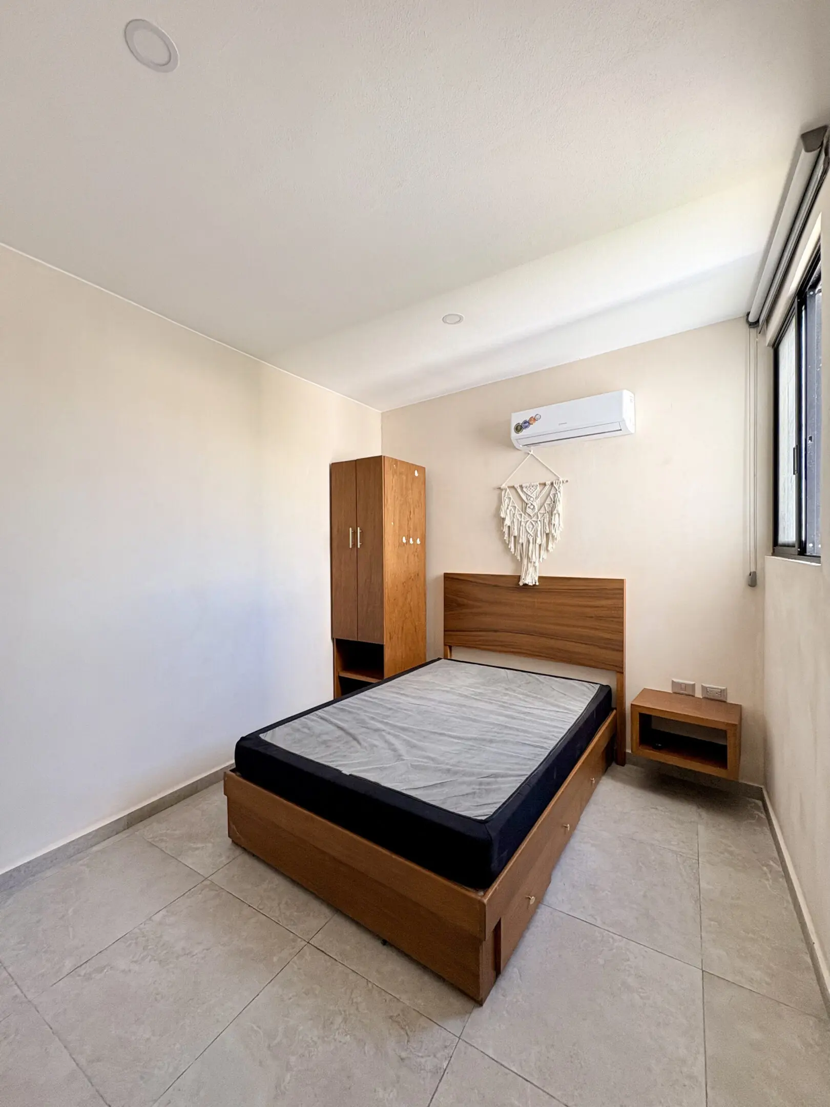 Minimal bedroom with wooden bed and AC