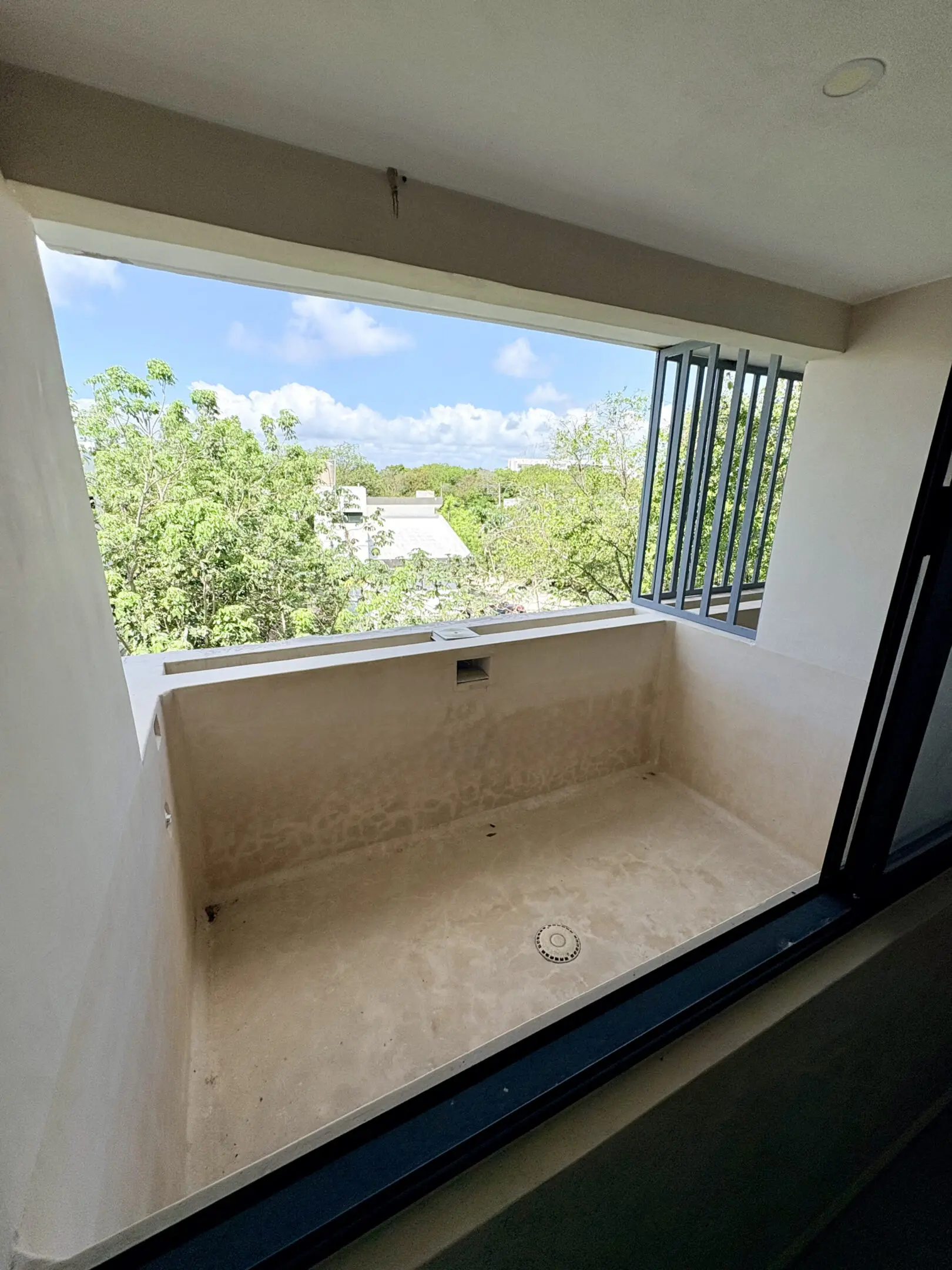 Empty concrete balcony overlooking treetops and sky