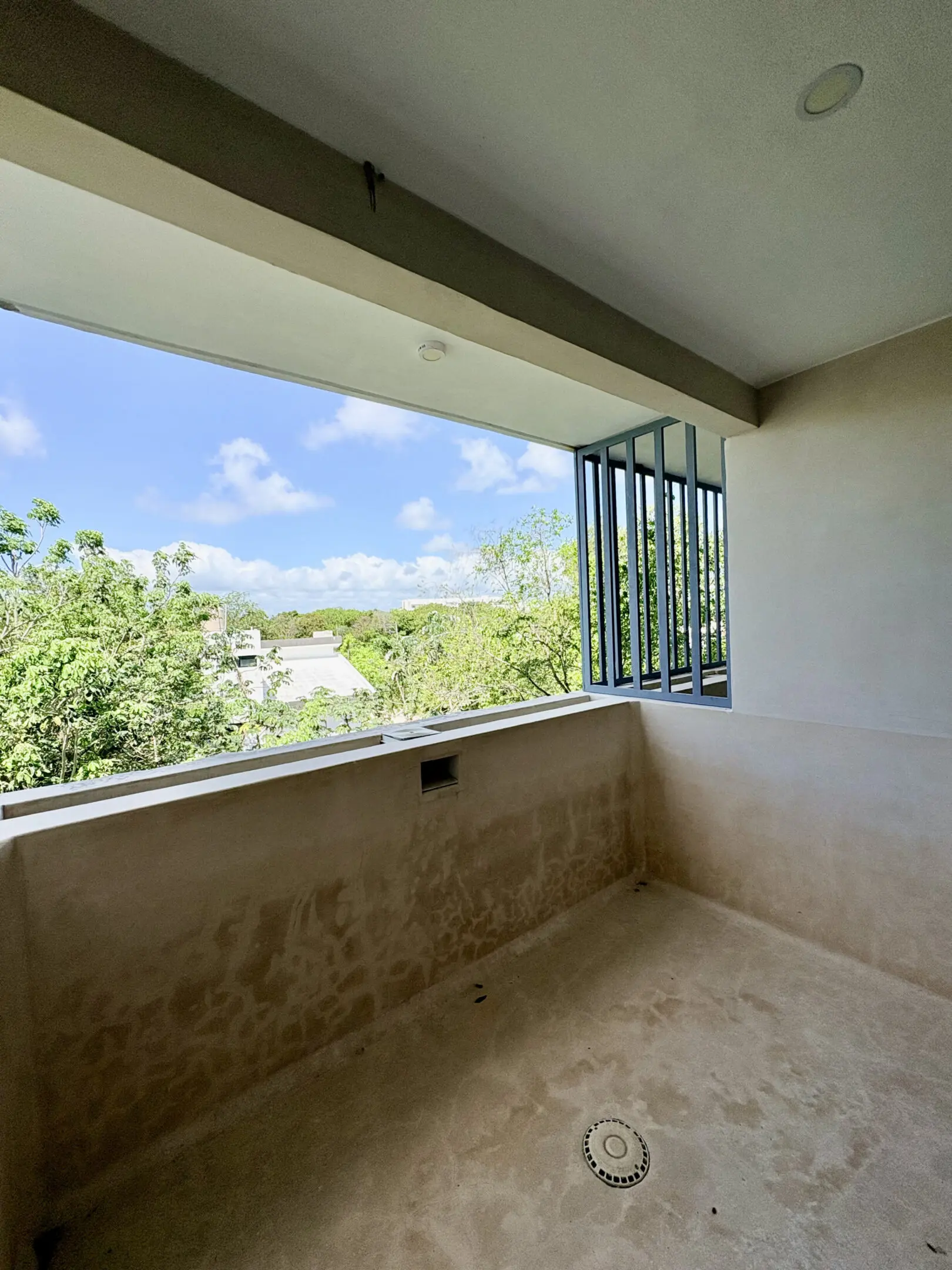 Empty balcony with view of treetops and sky