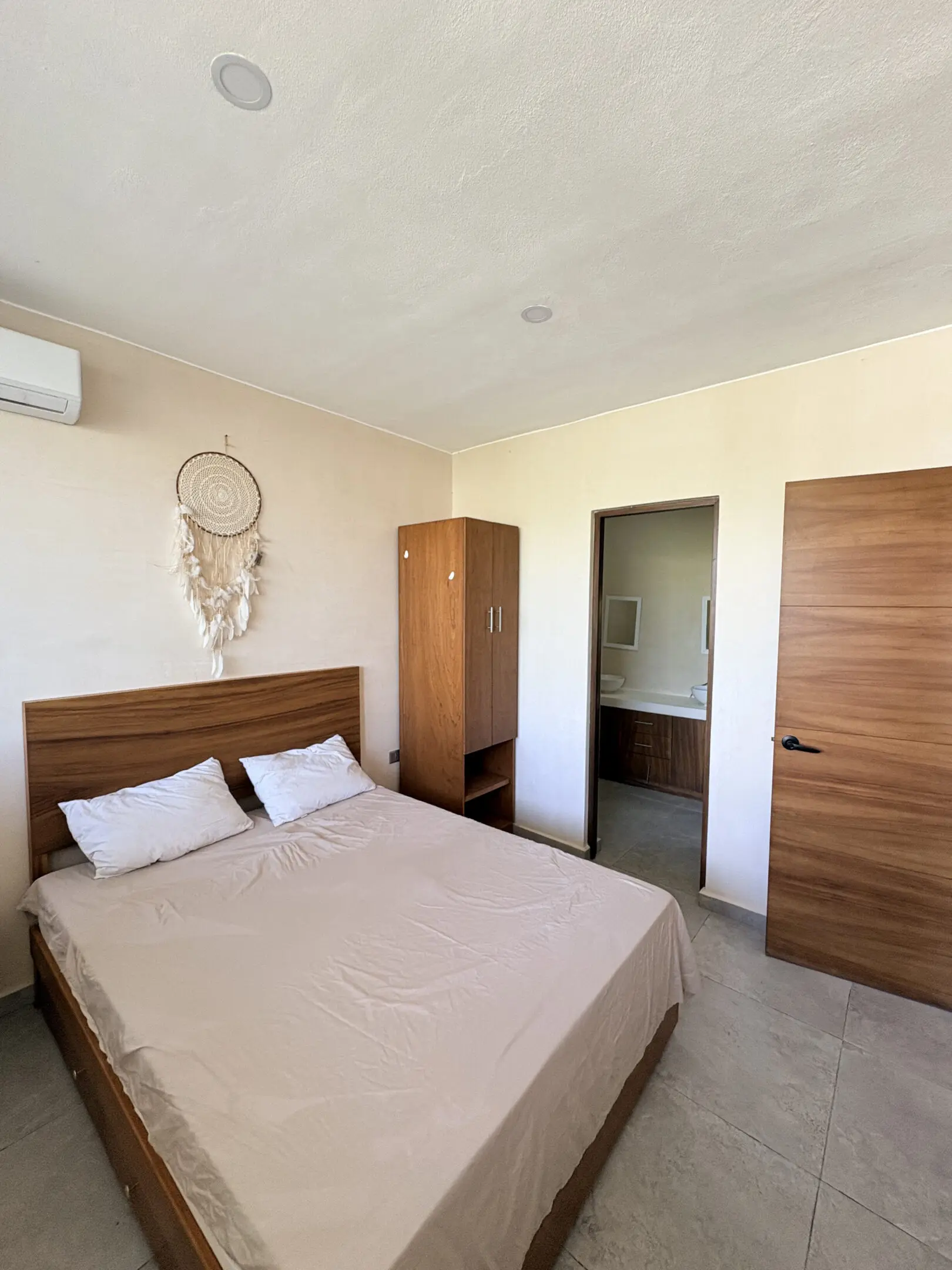 Minimal bedroom with wooden furniture and dreamcatcher