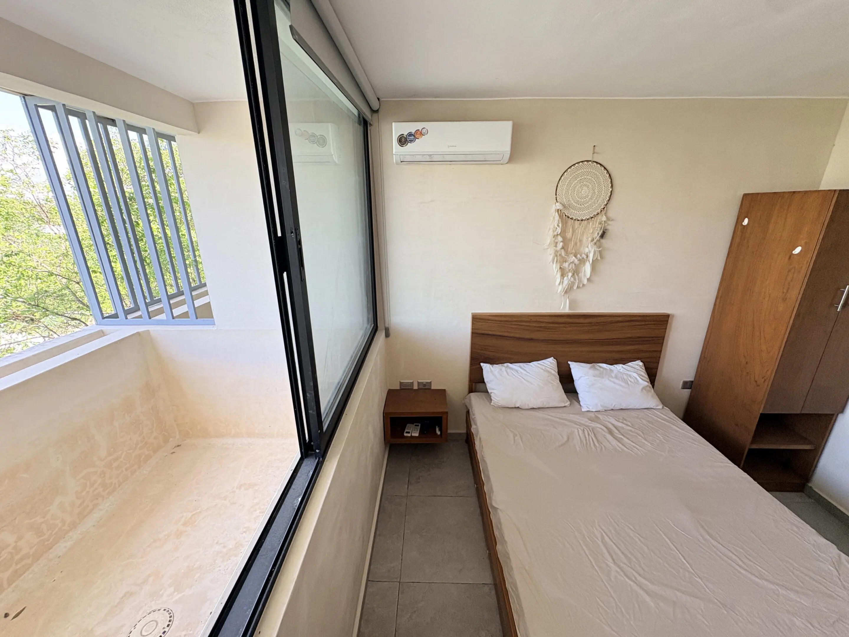 Minimal bedroom with bed, dreamcatcher, and balcony